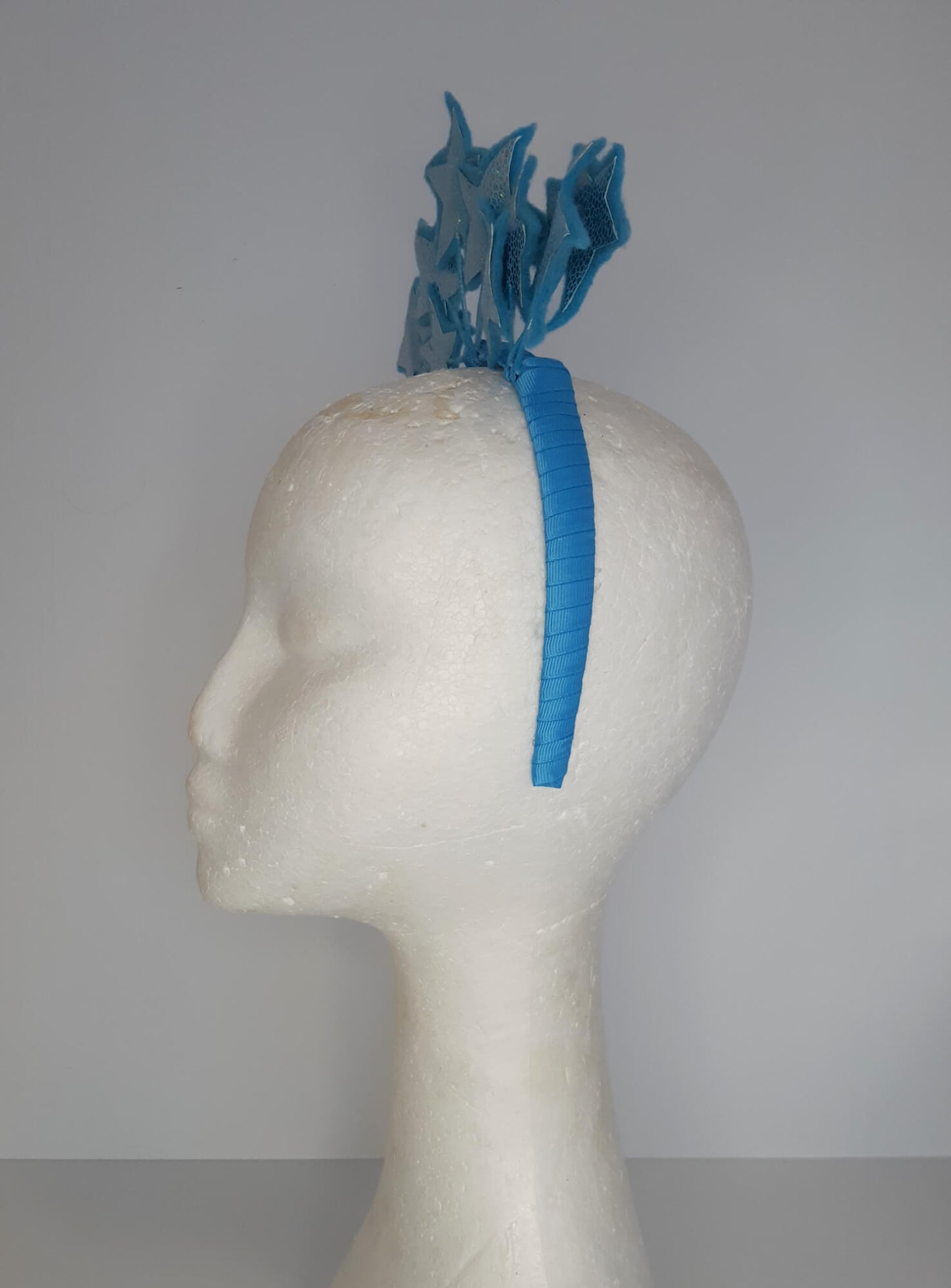 A picture of a blue millinery headband with stars  by Melissa Rath Millinery.