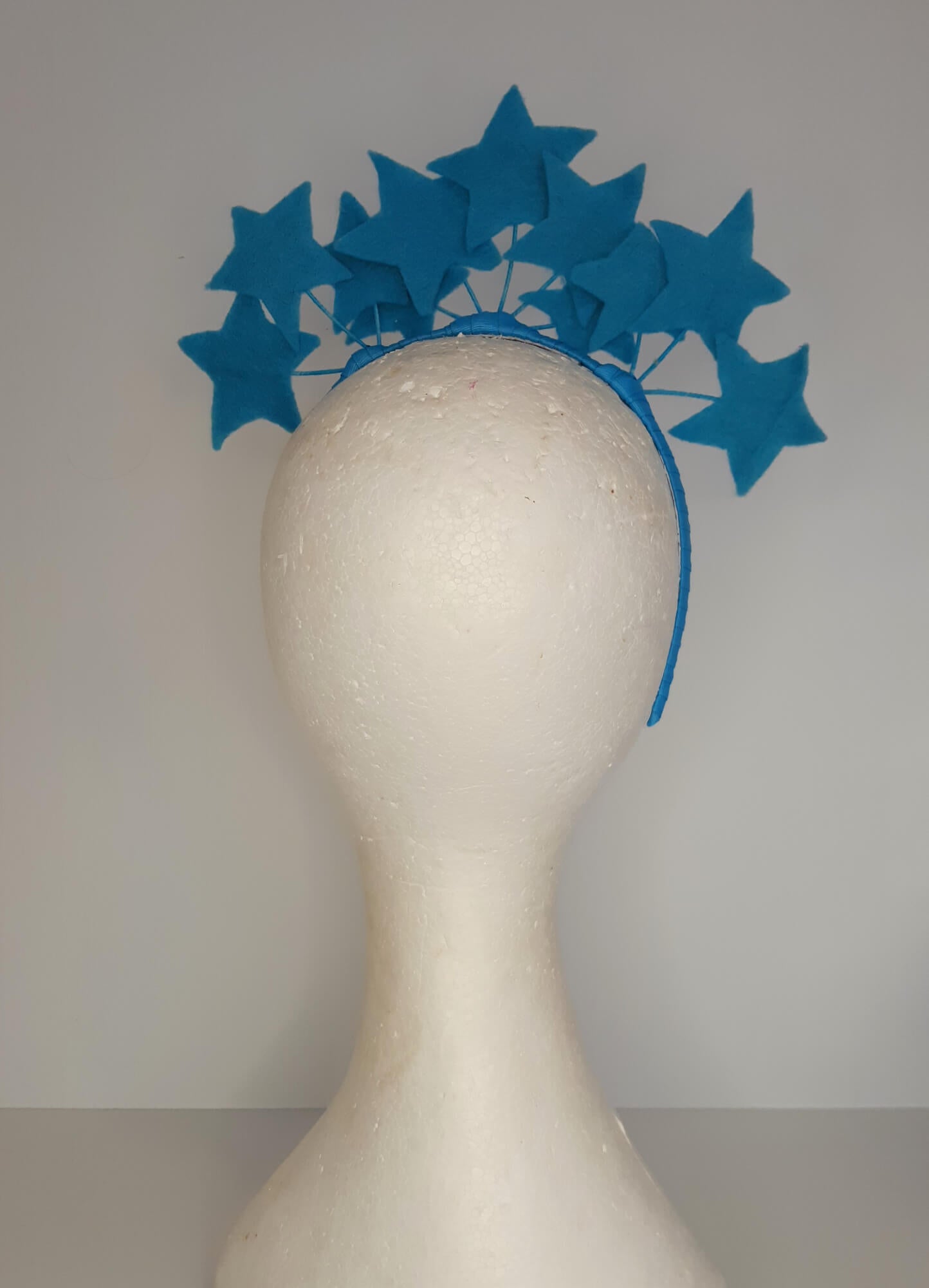 A picture of a blue millinery headband with stars  by Melissa Rath Millinery.