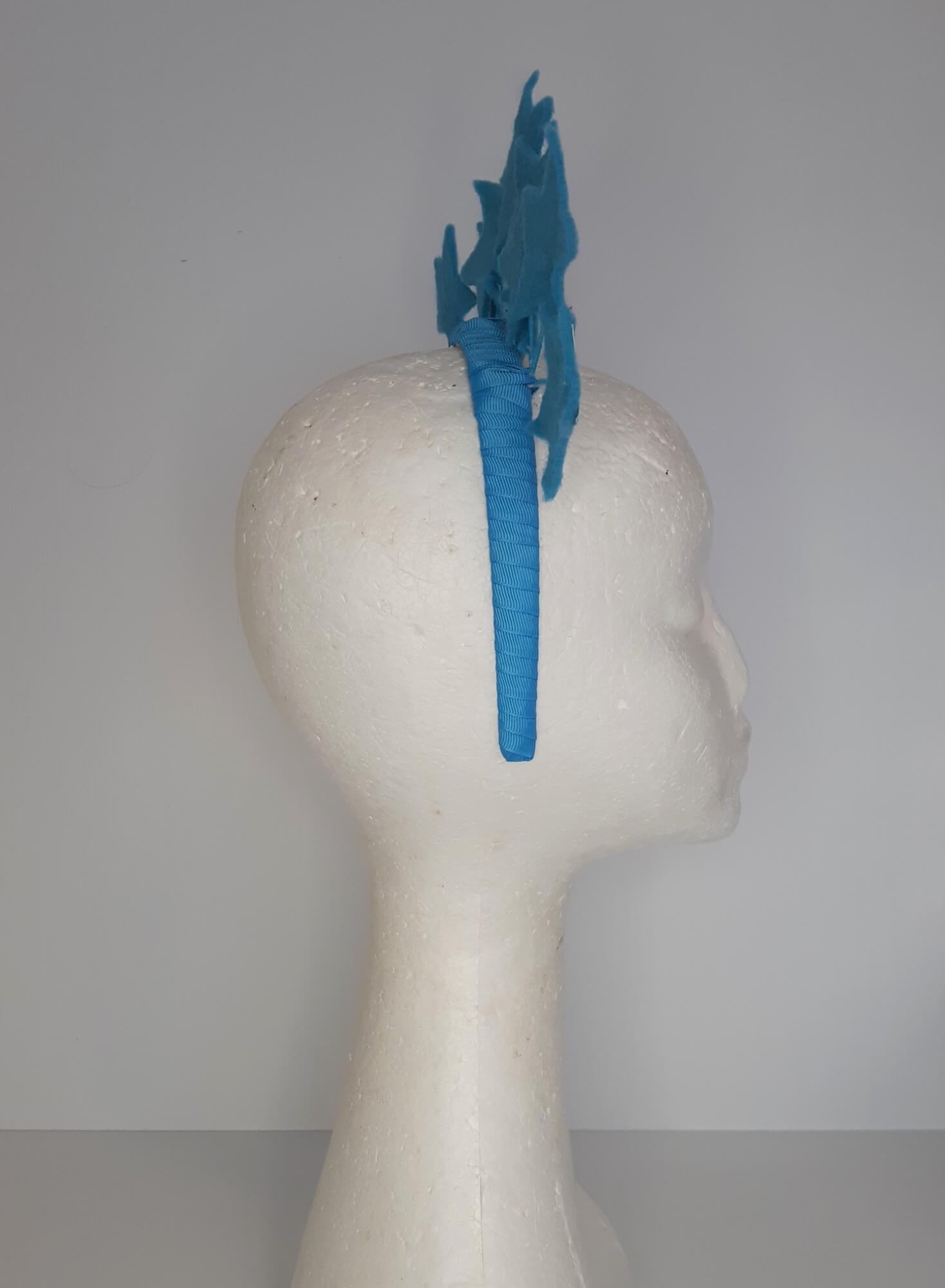 A picture of a blue millinery headband with stars  by Melissa Rath Millinery.