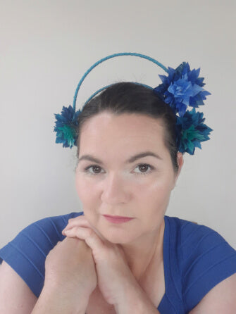A picture of a blue and green feathered halo crown by Melissa Rath Millinery