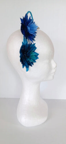 A picture of a blue and green feathered halo crown by Melissa Rath Millinery