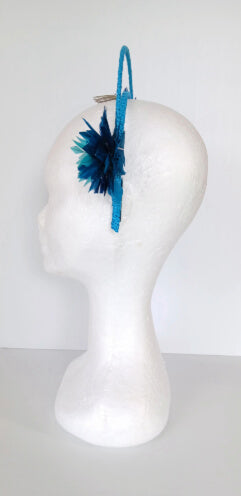 A picture of a blue and green feathered halo crown by Melissa Rath Millinery