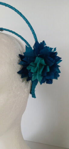 A picture of a blue and green feathered halo crown by Melissa Rath Millinery