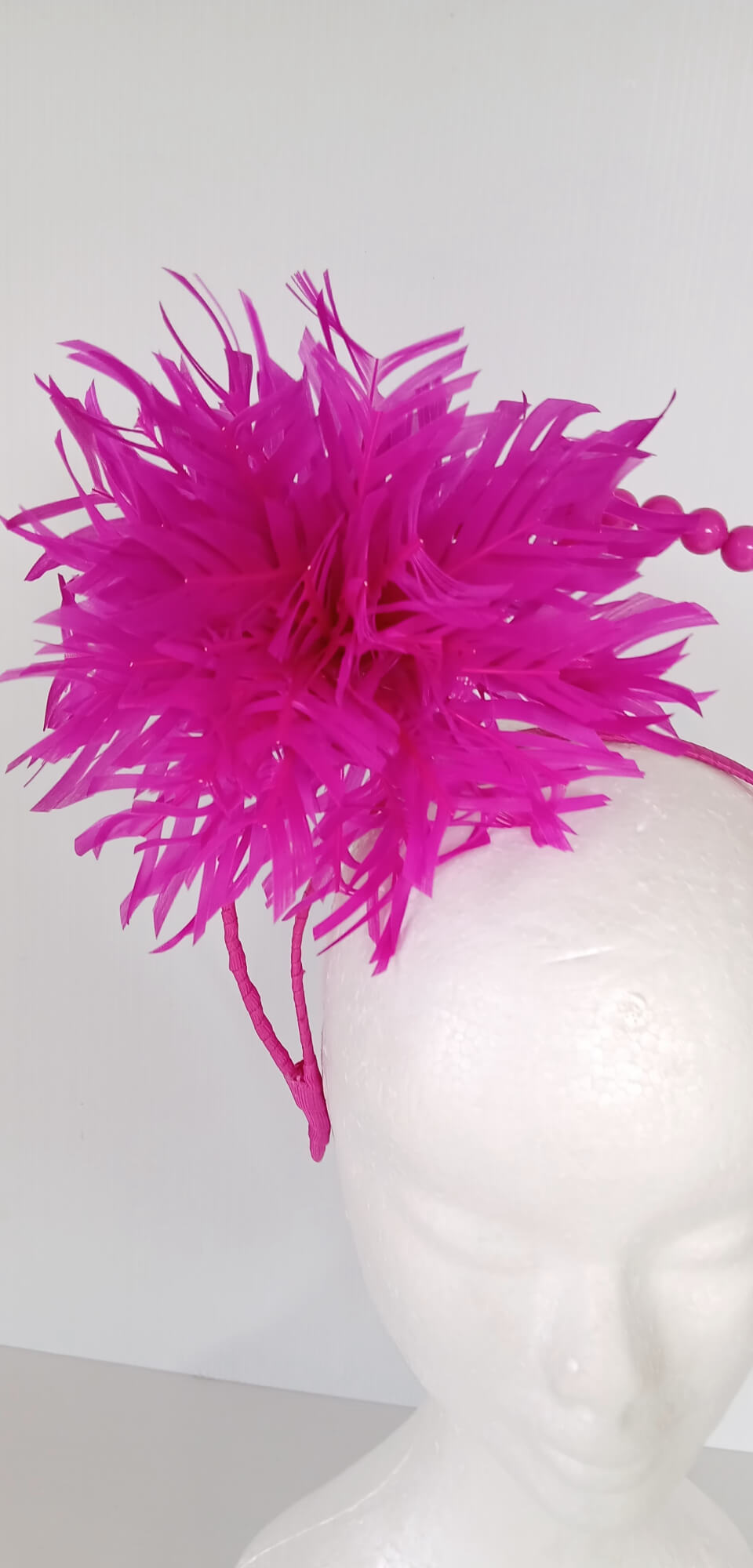 A picture of a Pink Halo Beaded Headband with feather flower by Melissa Rath Millinery.
