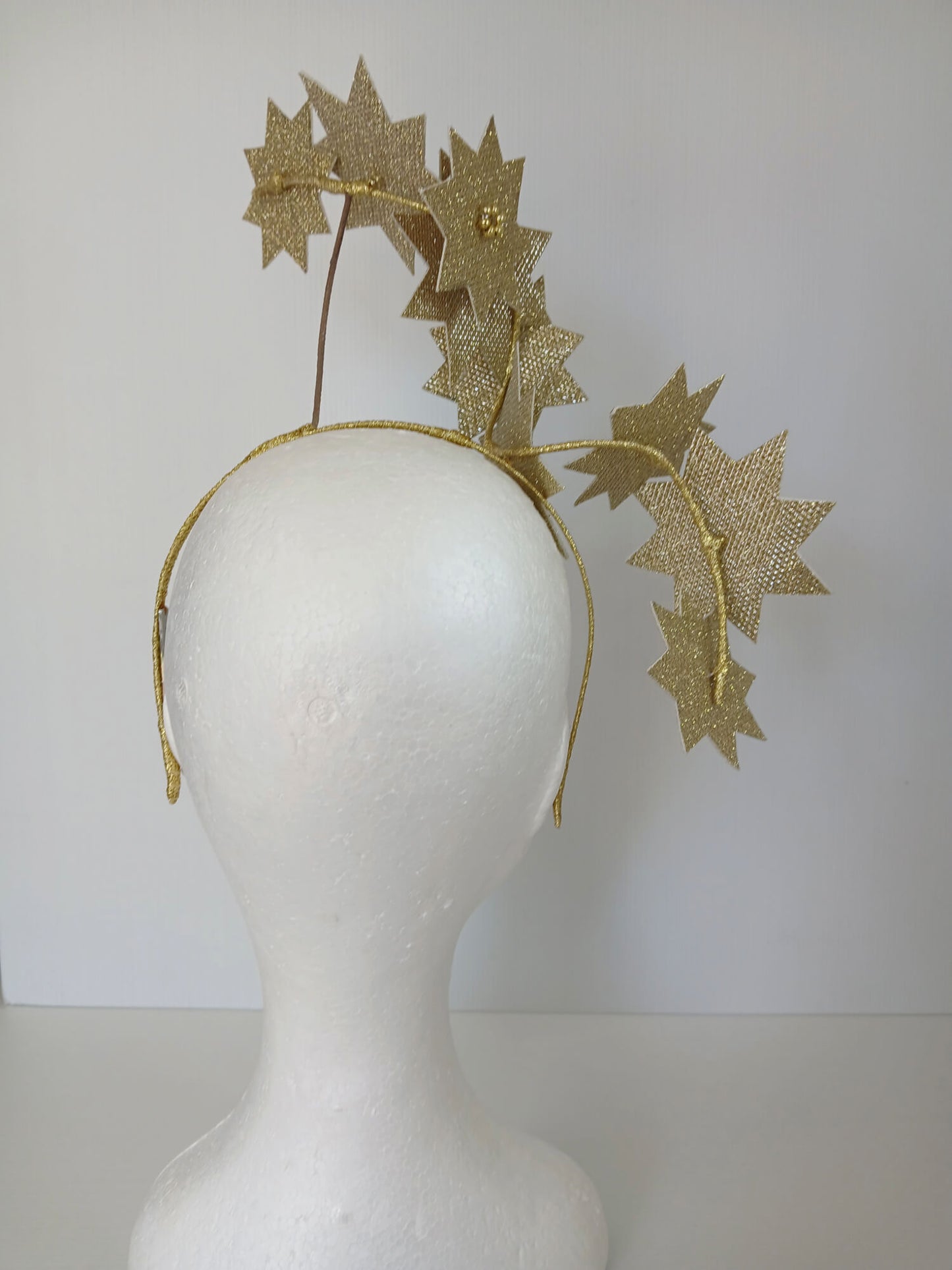 A picture of a Gold Pleather Millinery Fascinator by Melissa Rath Millinery