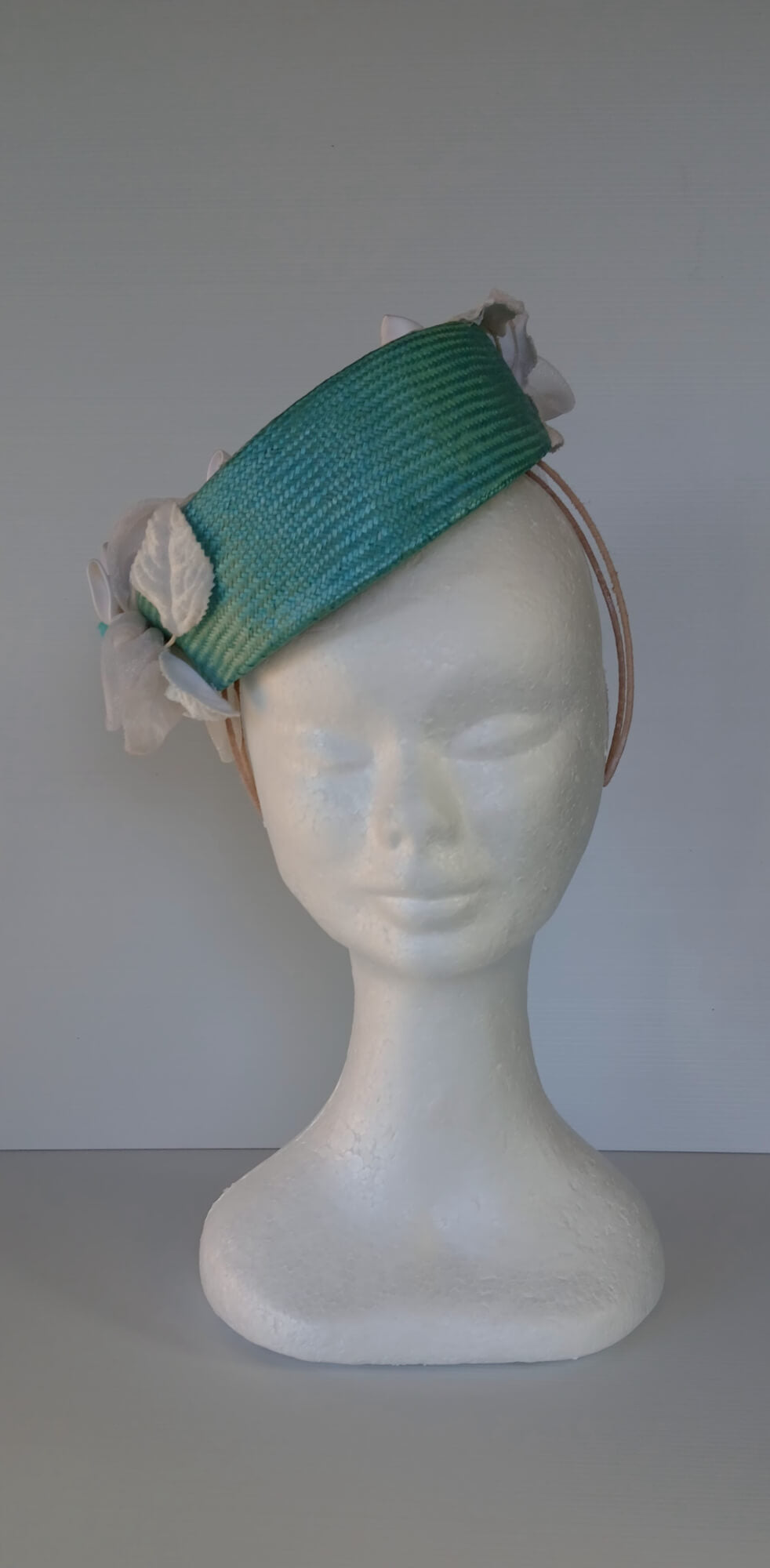 A picture of a Green Millinery Pillbox Hat with white velvet trim by Melissa Rath Millinery.