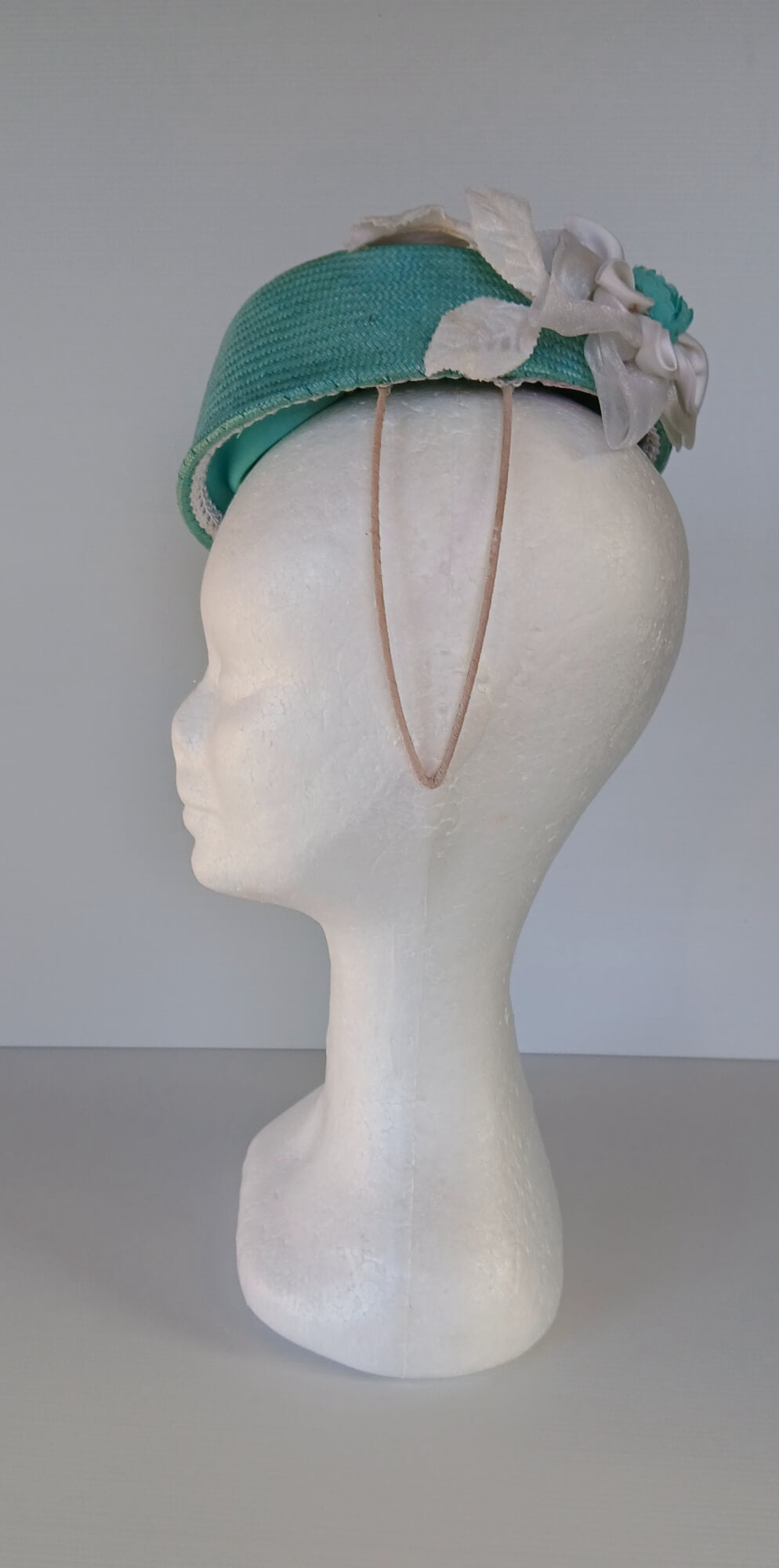 A picture of a Green Millinery Pillbox Hat with white velvet trim by Melissa Rath Millinery.