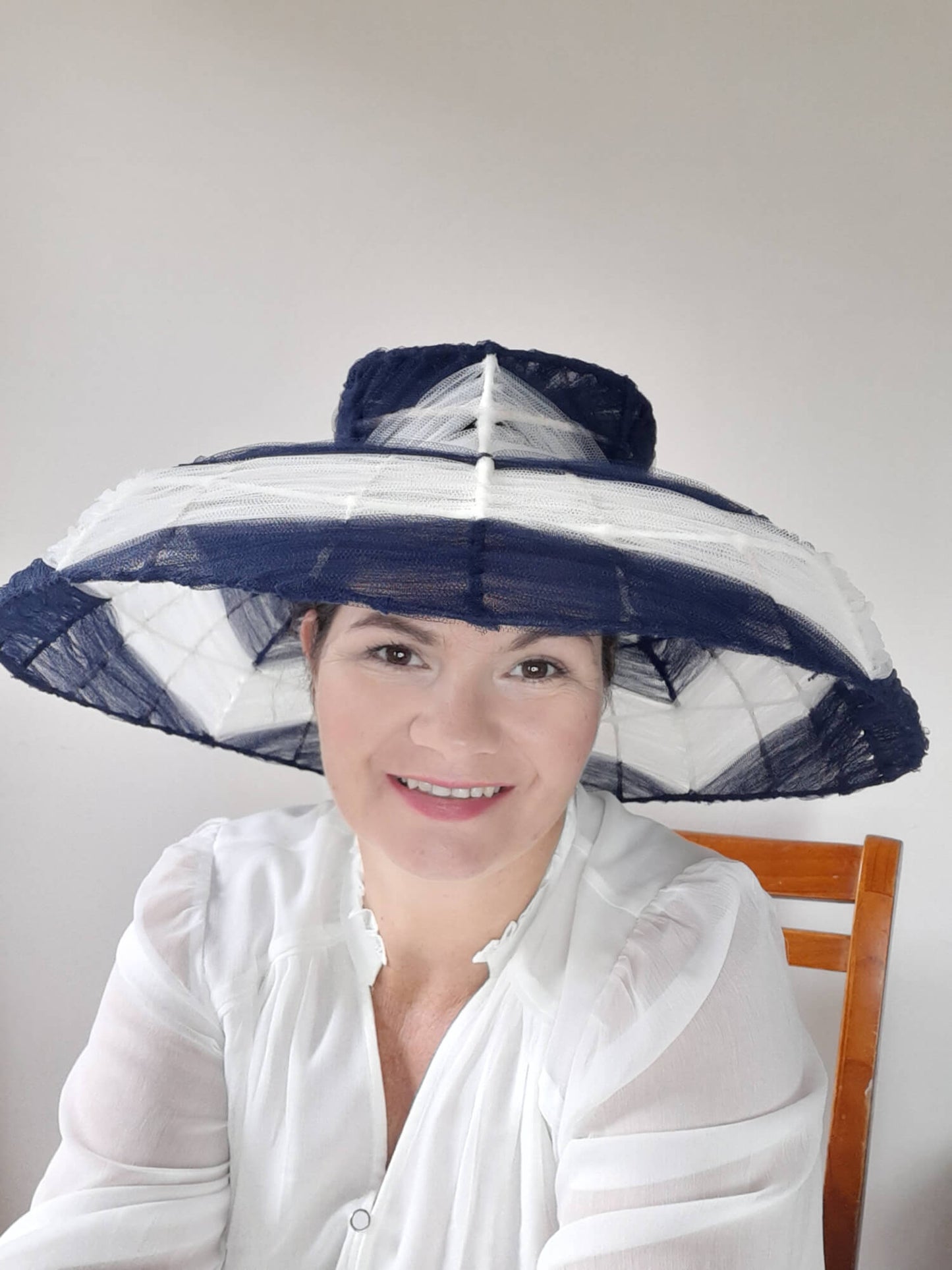 A picture of a navy and white wire and tulle millinery hat by Melissa Rath Millinery.