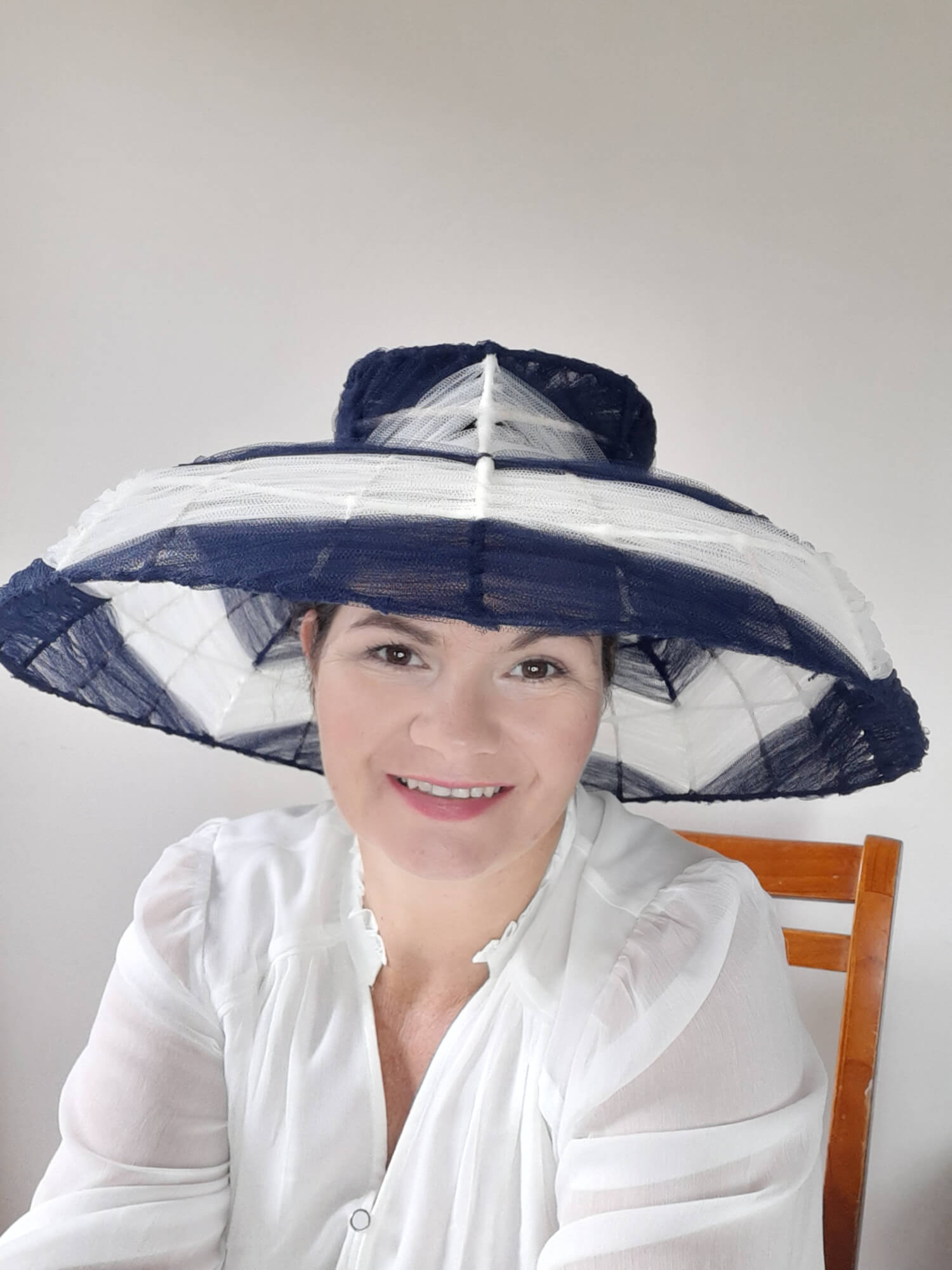 A picture of a navy and white wire and tulle millinery hat by Melissa Rath Millinery.