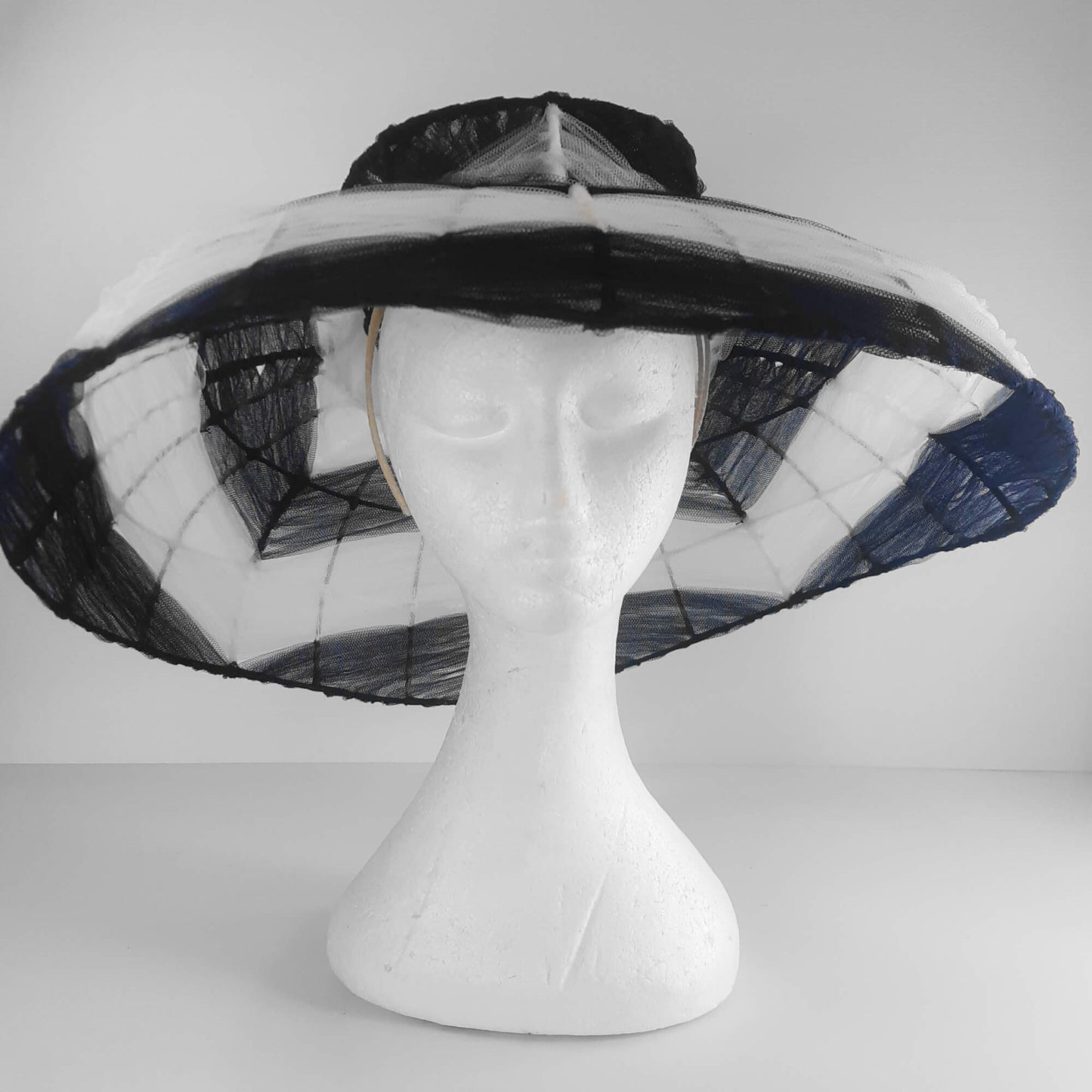 A picture of a navy and white wire and tulle millinery hat by Melissa Rath Millinery.