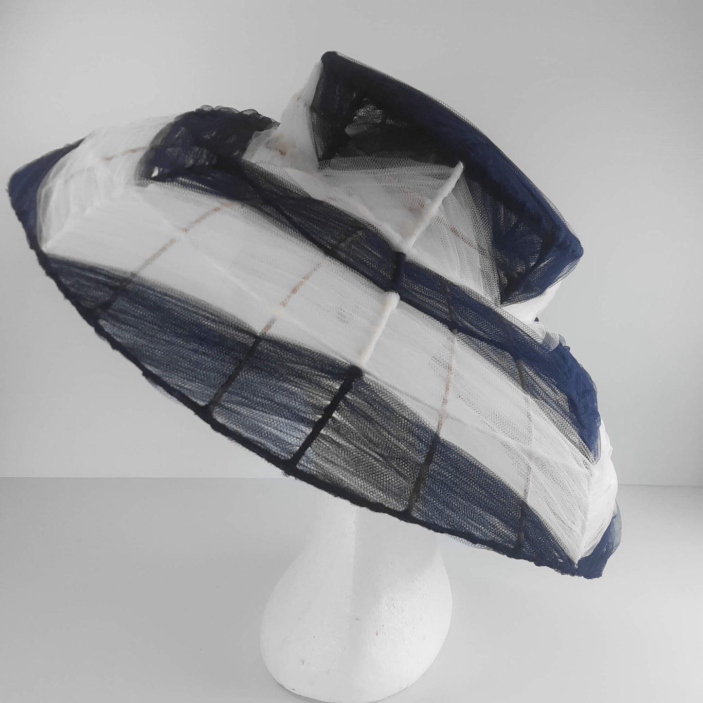 A picture of a navy and white wire and tulle millinery hat by Melissa Rath Millinery.