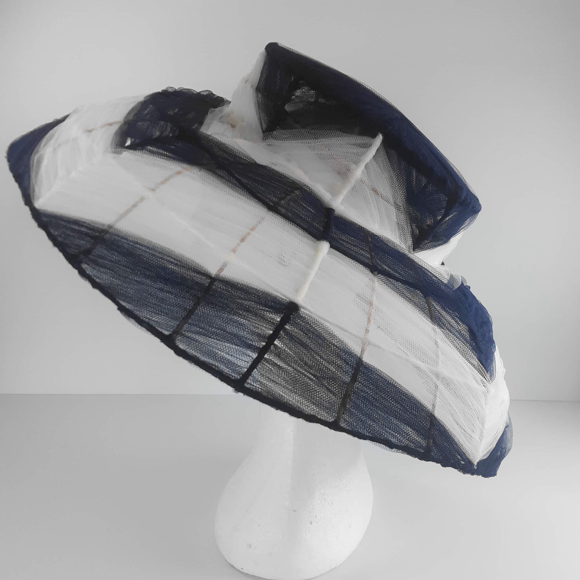 A picture of a navy and white wire and tulle millinery hat by Melissa Rath Millinery.