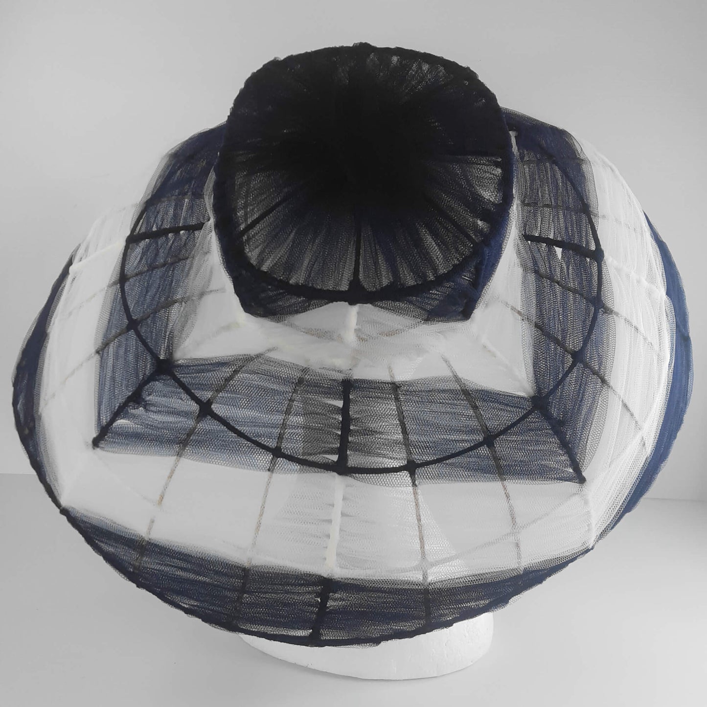 A picture of a navy and white wire and tulle millinery hat by Melissa Rath Millinery.