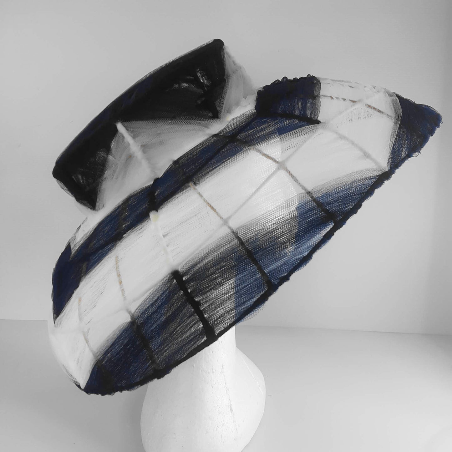 A picture of a navy and white wire and tulle millinery hat by Melissa Rath Millinery.