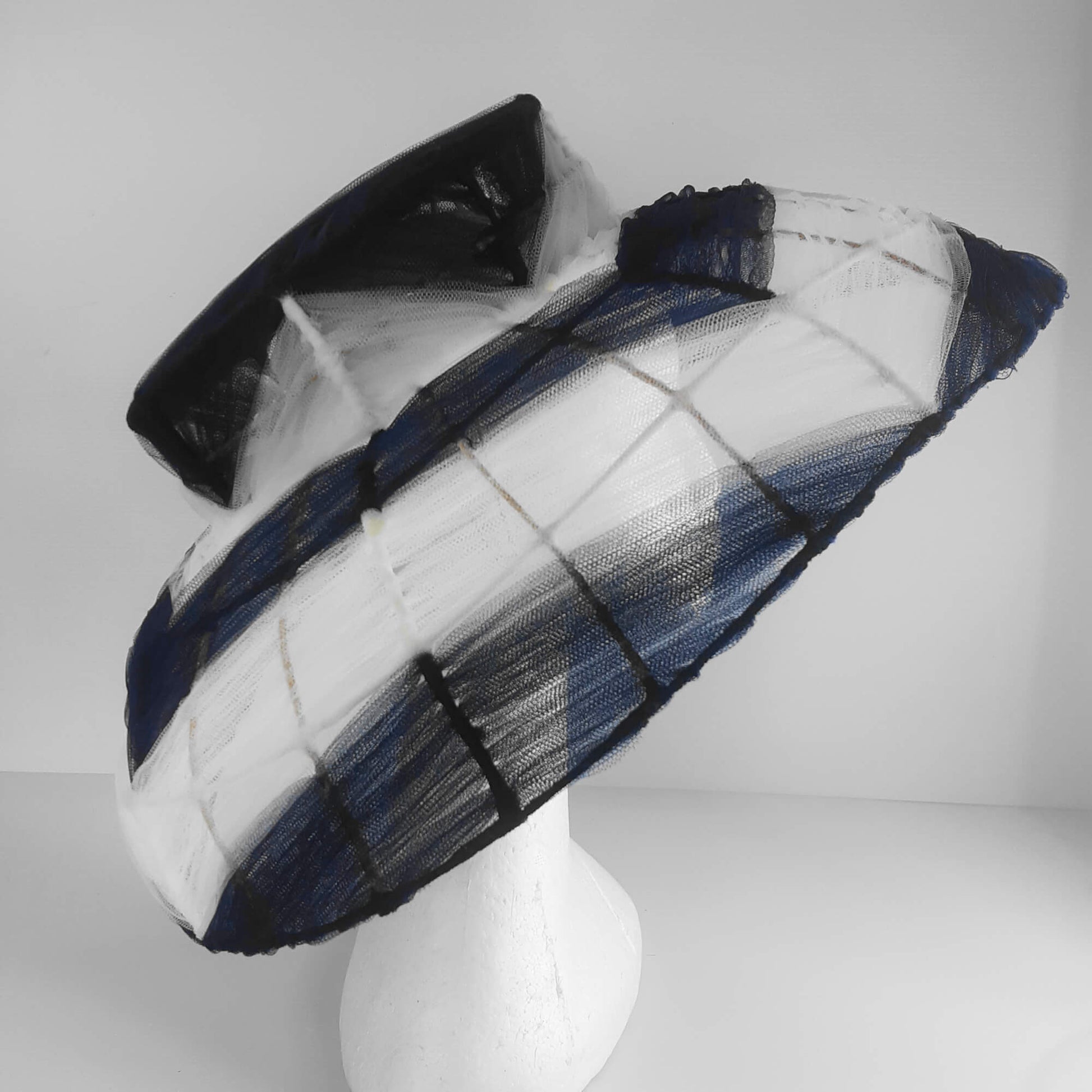 A picture of a navy and white wire and tulle millinery hat by Melissa Rath Millinery.