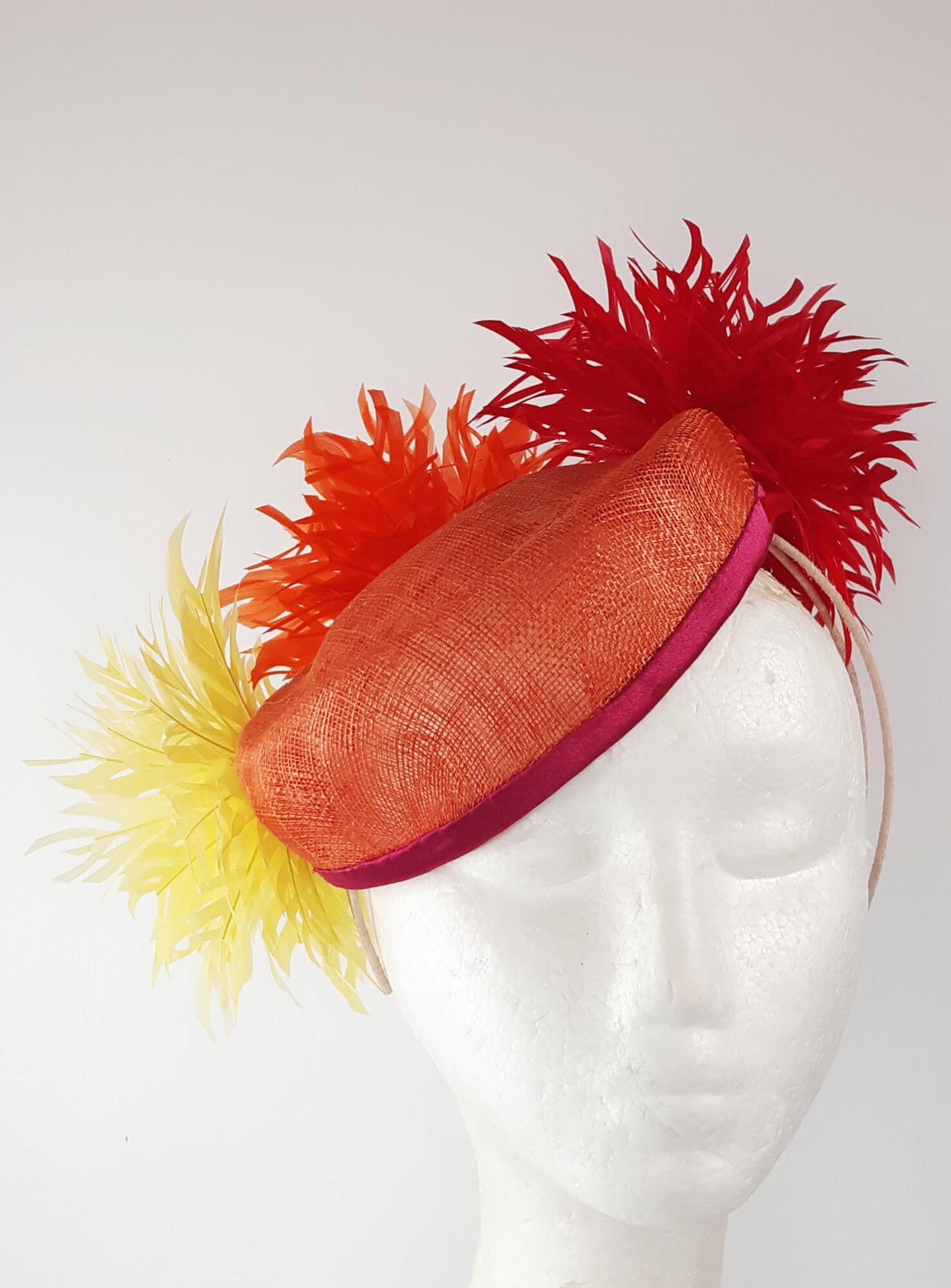 A picture of an Orange, Red and Yellow Millinery Pillbox Hat by Melissa Rath Millinery.