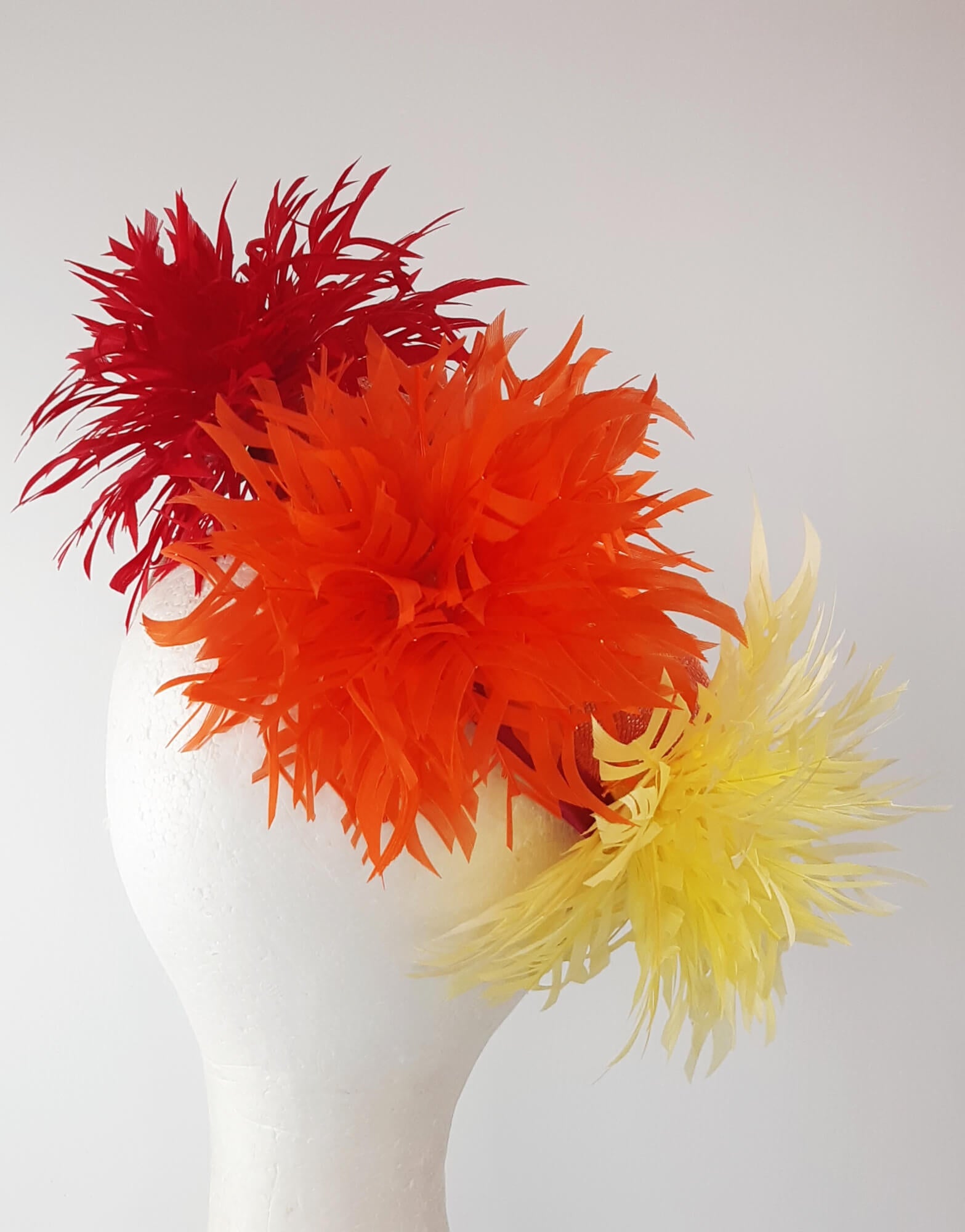 A picture of an Orange, Red and Yellow Millinery Pillbox Hat by Melissa Rath Millinery.