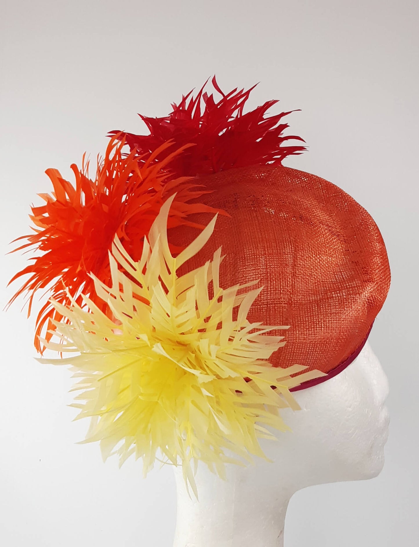 A picture of an Orange, Red and Yellow Millinery Pillbox Hat by Melissa Rath Millinery.
