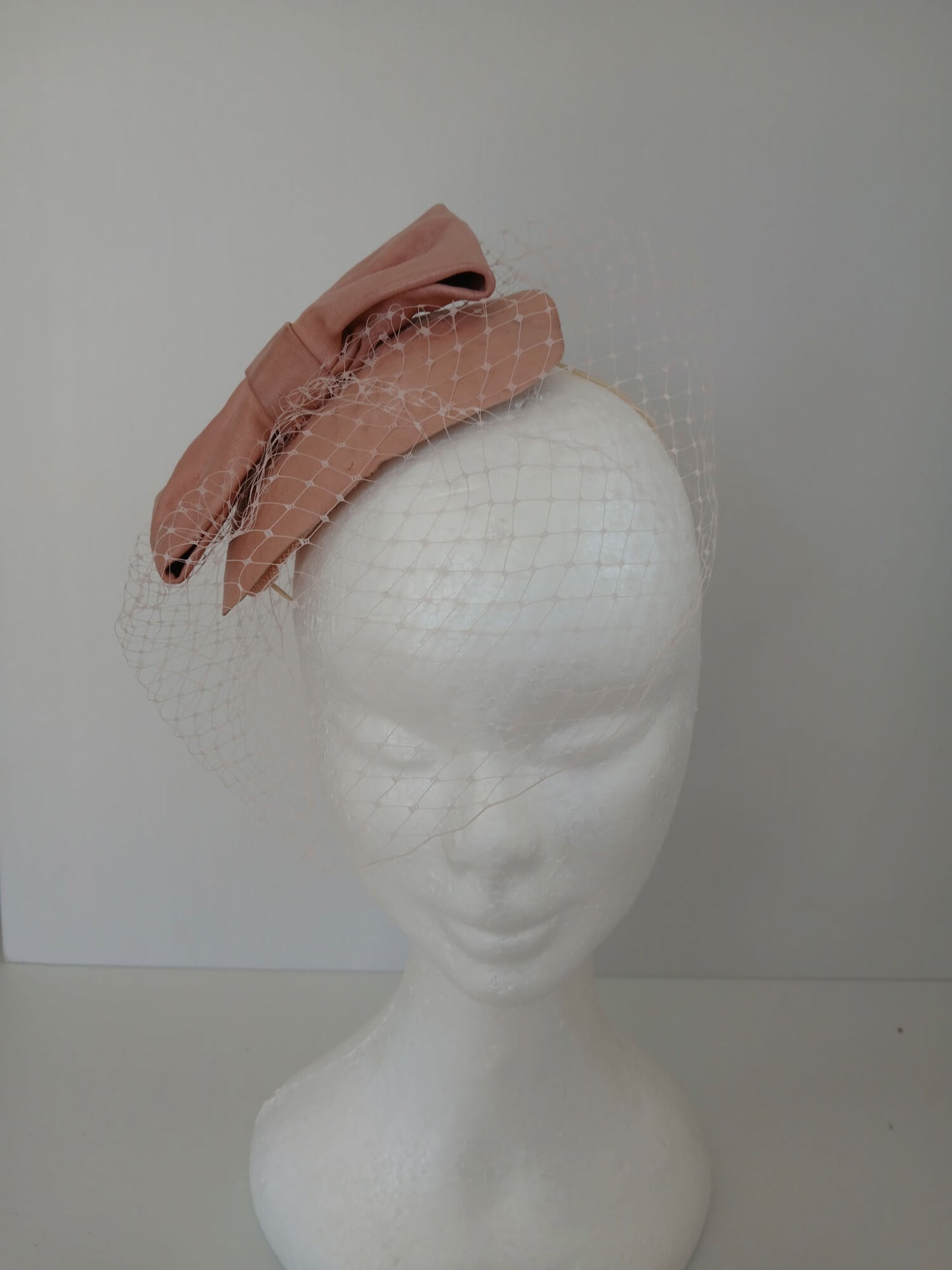 A picture of a Pink Veiled Leather Millinery Fascinator by Melissa Rath Millinery.