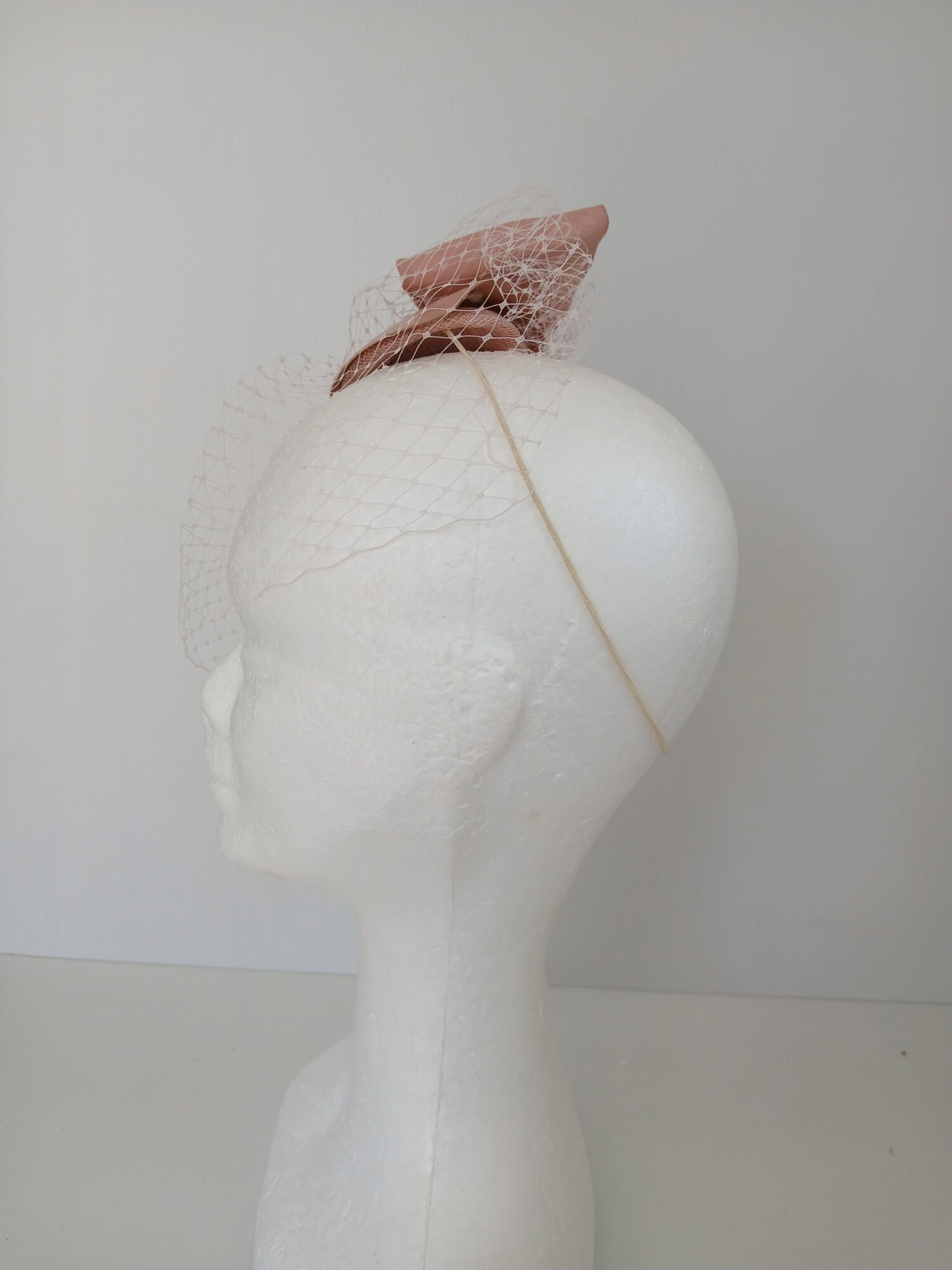 A picture of a Pink Veiled Leather Millinery Fascinator by Melissa Rath Millinery.