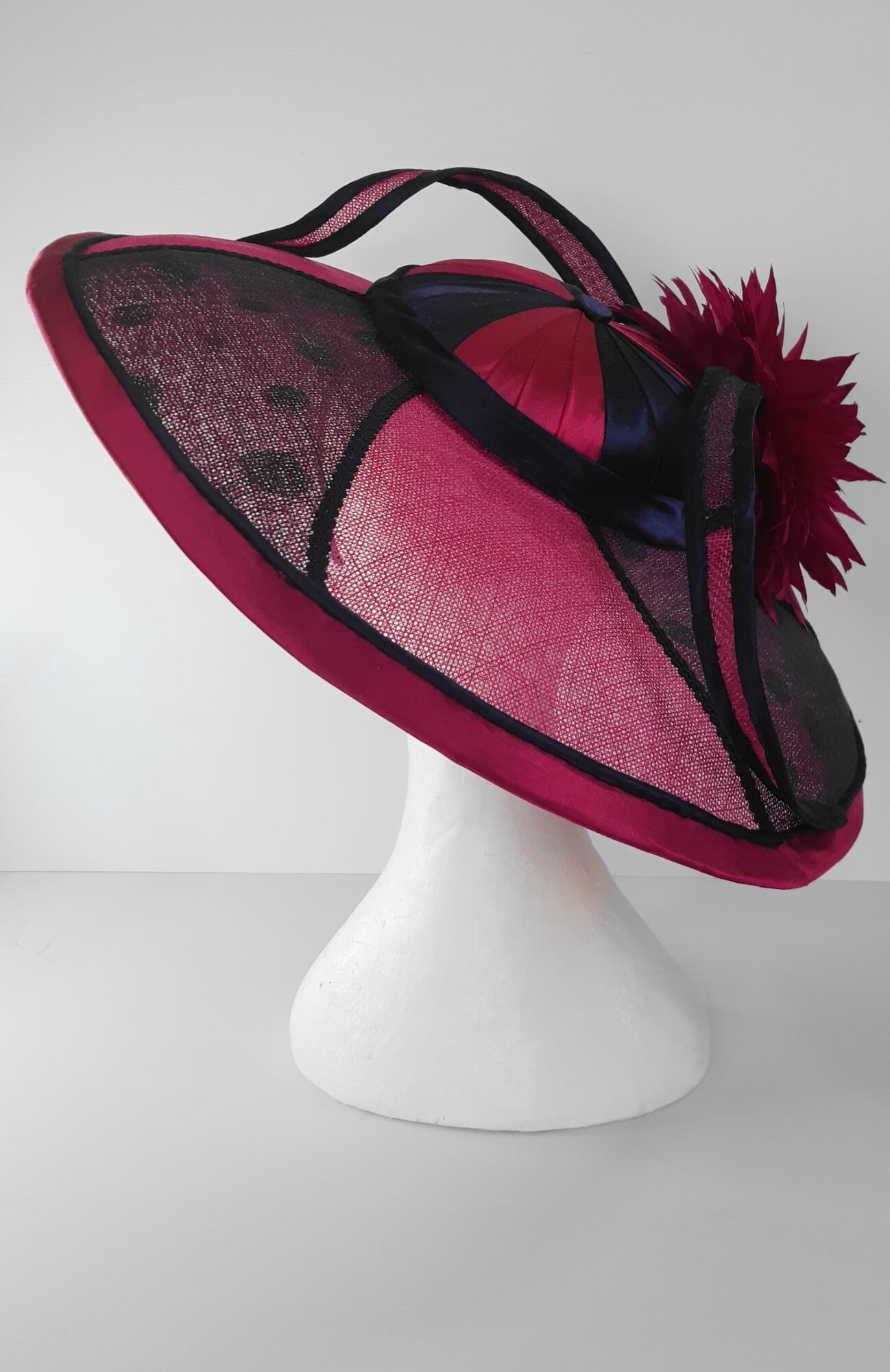 A picture of a Pink and Navy Wide Brimmed Hat by Melissa Rath Millinery.