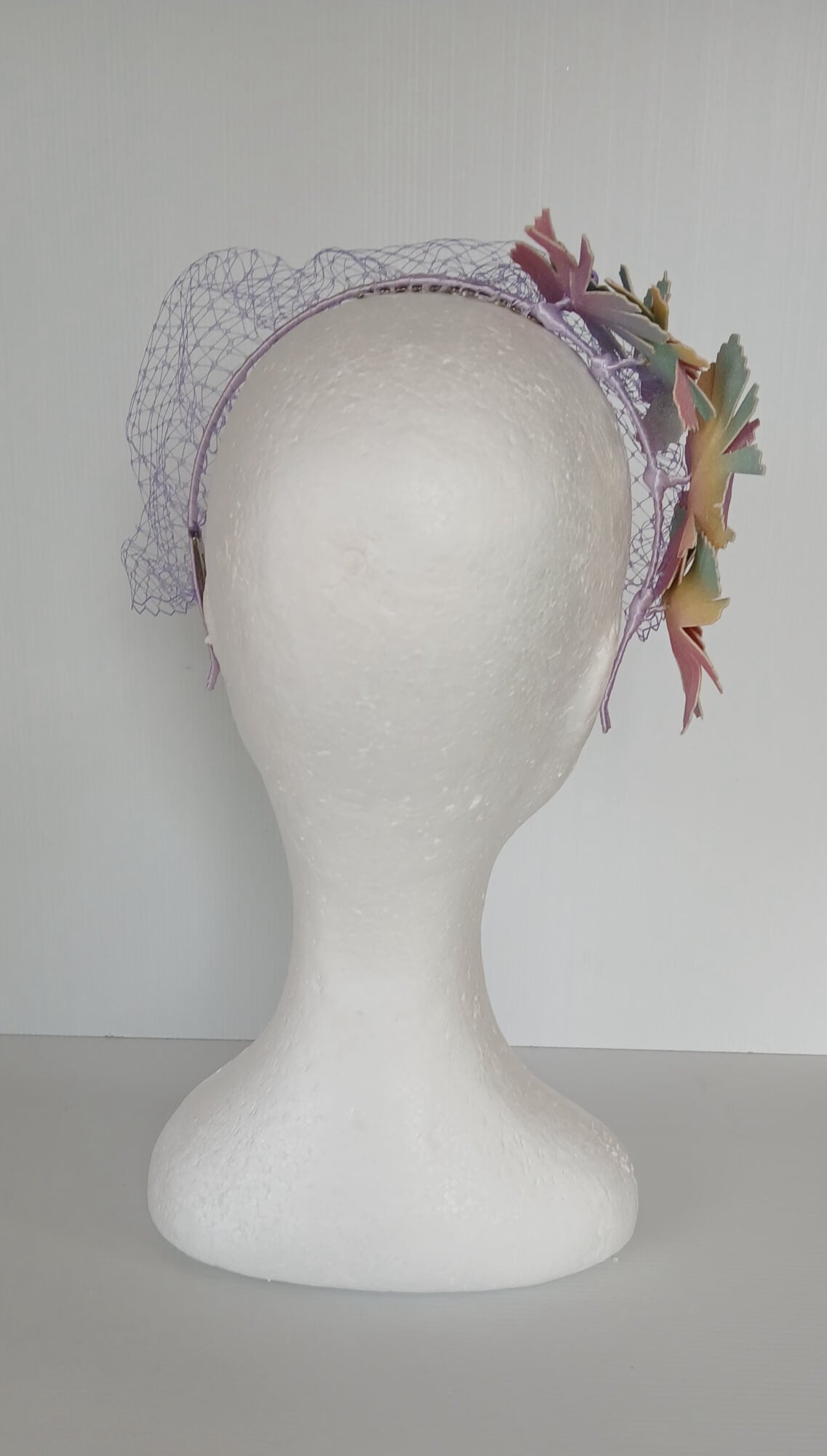 A picture of a Rainbow Veiled Millinery Headband by Melissa Rath Millinery.