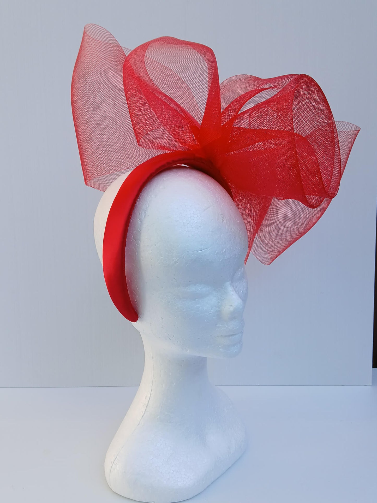 An image of a Red Padded Headband with Crinoline Bow and Rose by Melissa Rath Millinery.