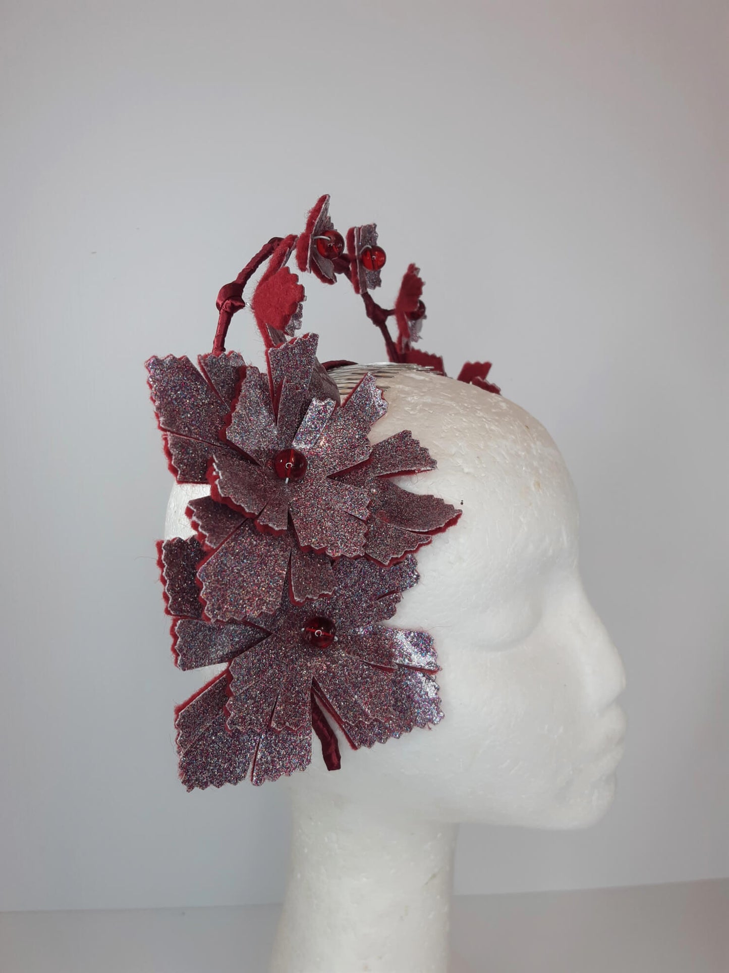 A picture of a red millinery crown halo by Melissa Rath Millinery.