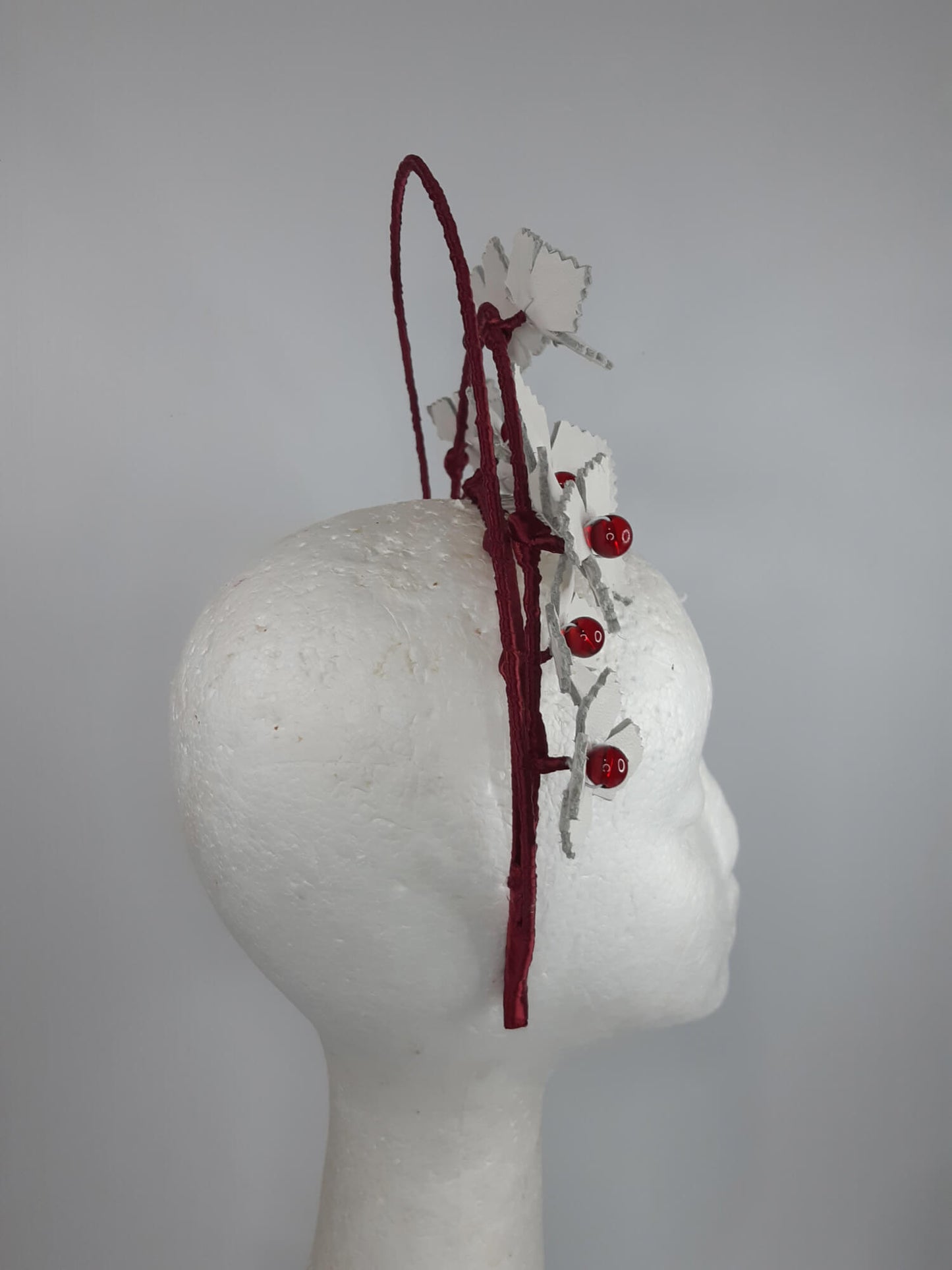 A picture of a Red and White Leather Millinery Halo Crown by Melissa Rath Millinery.
