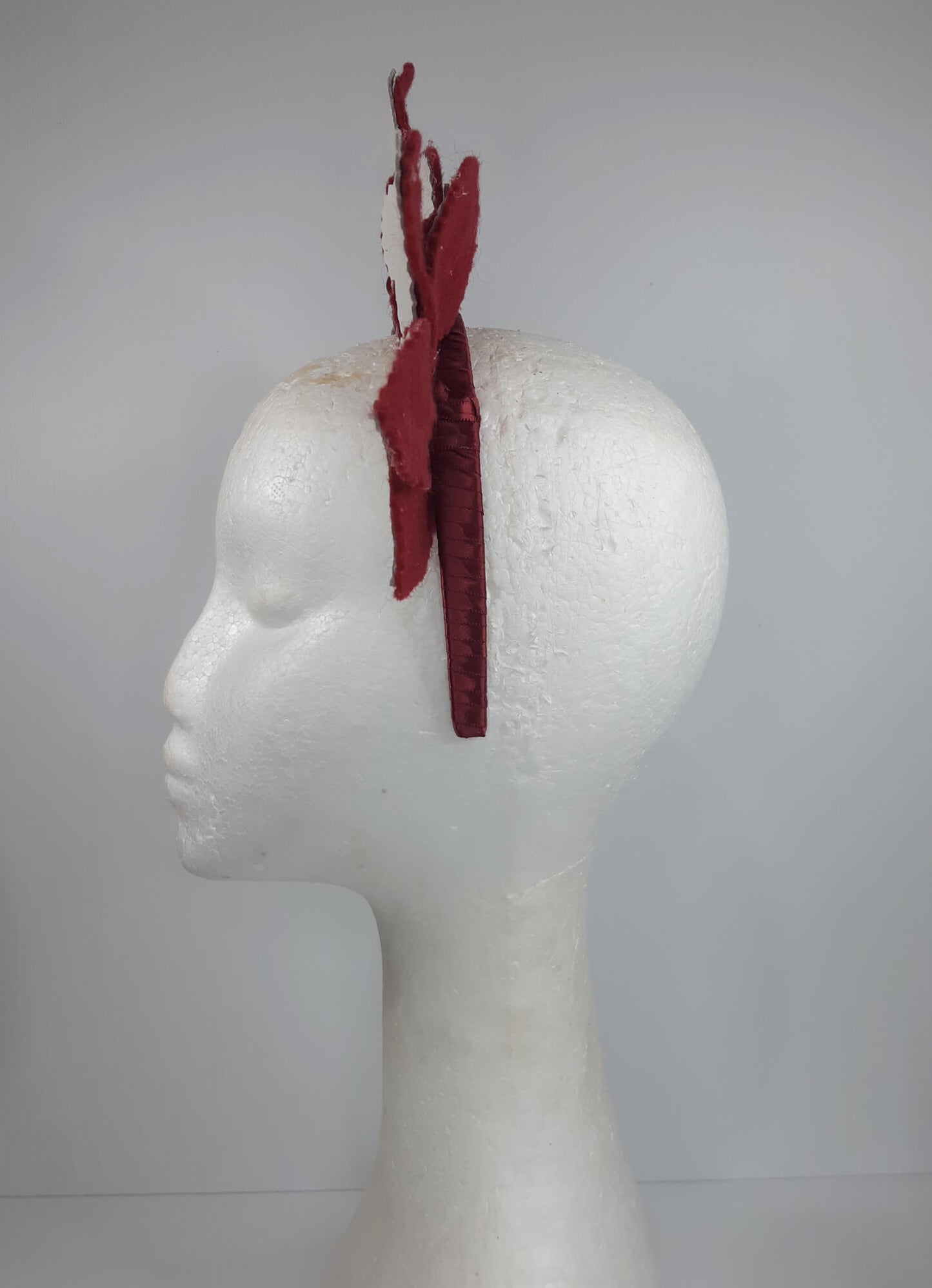 A picture of a red and white leather headband by Melissa Rath Millinery