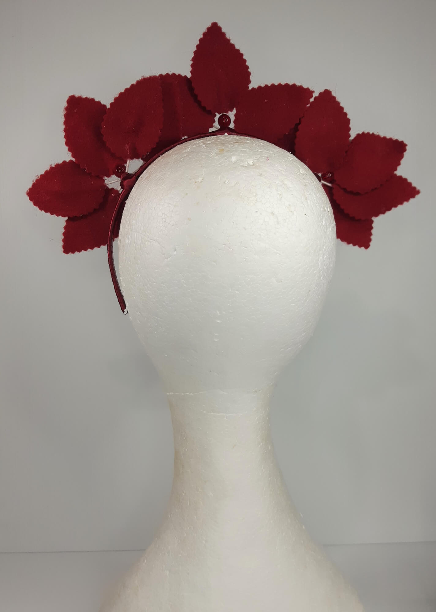 A picture of a red and white leather headband by Melissa Rath Millinery