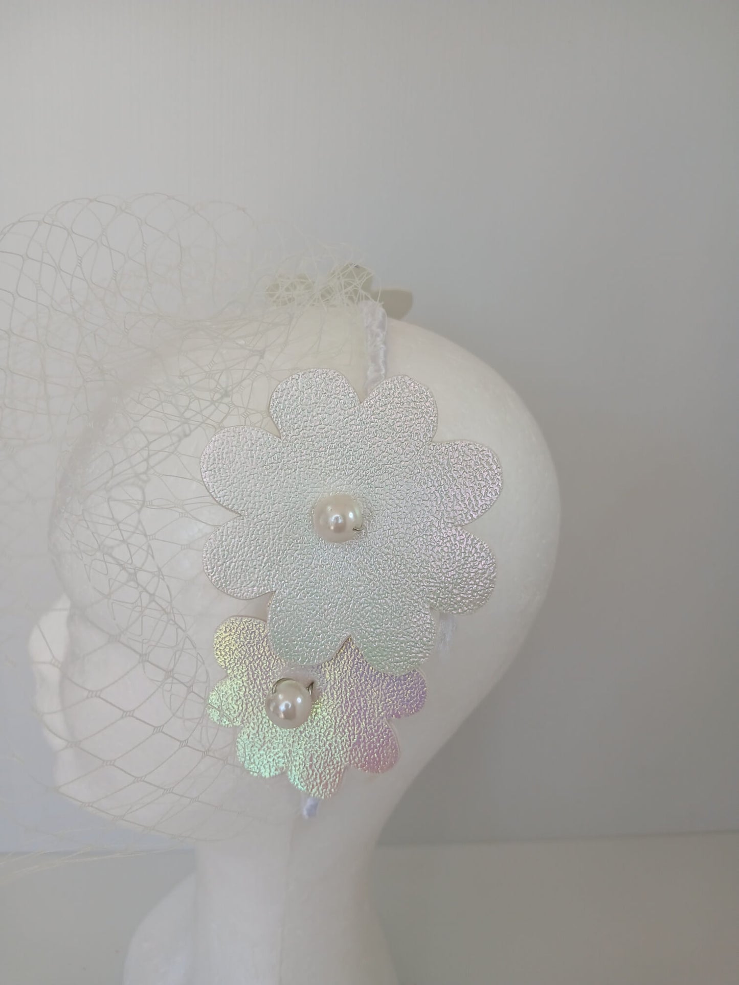 A picture of a White Pleather Veiled Millinery Headband by Melissa Rath Millinery.