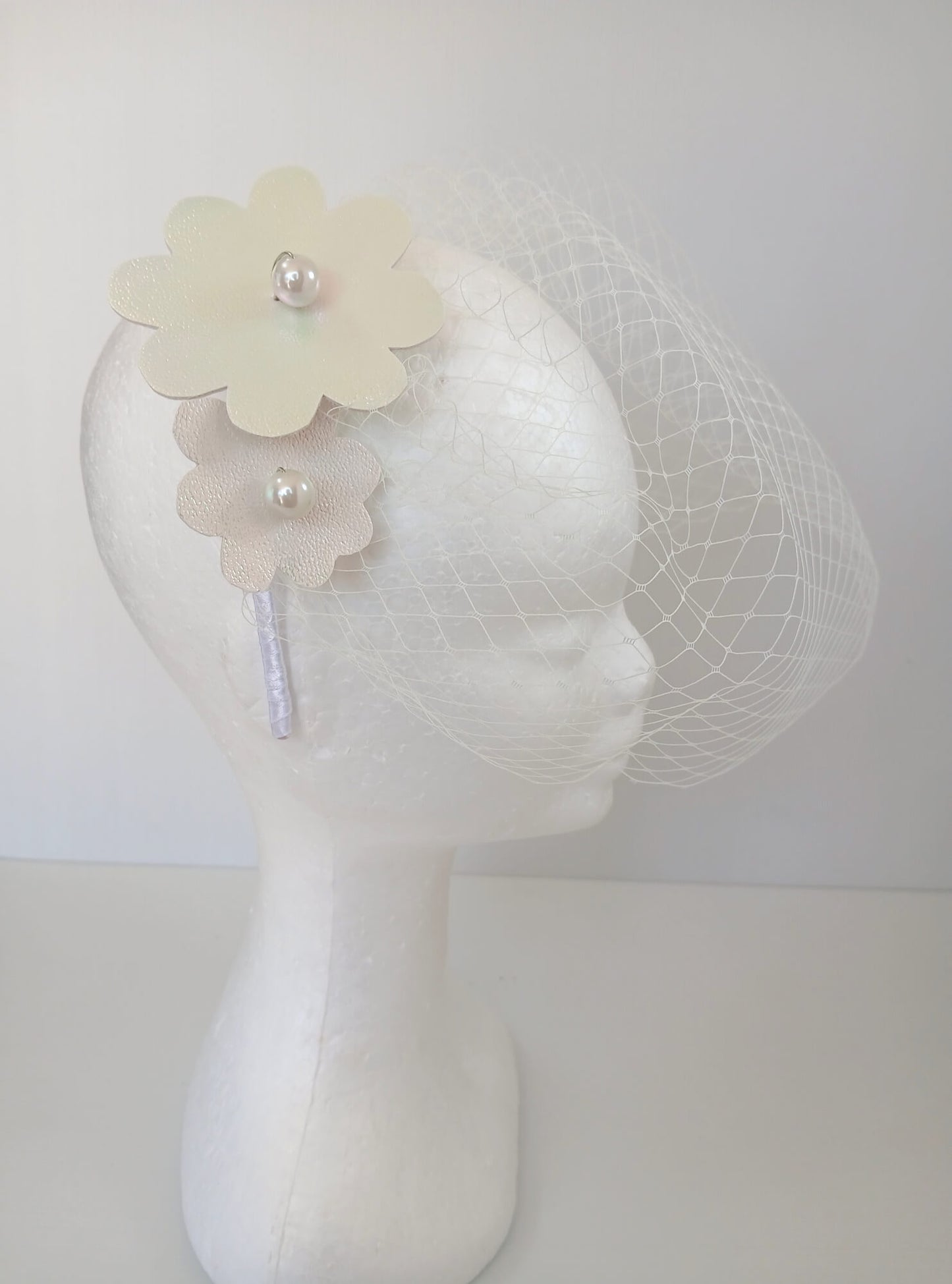 A picture of a White Pleather Veiled Millinery Headband by Melissa Rath Millinery.