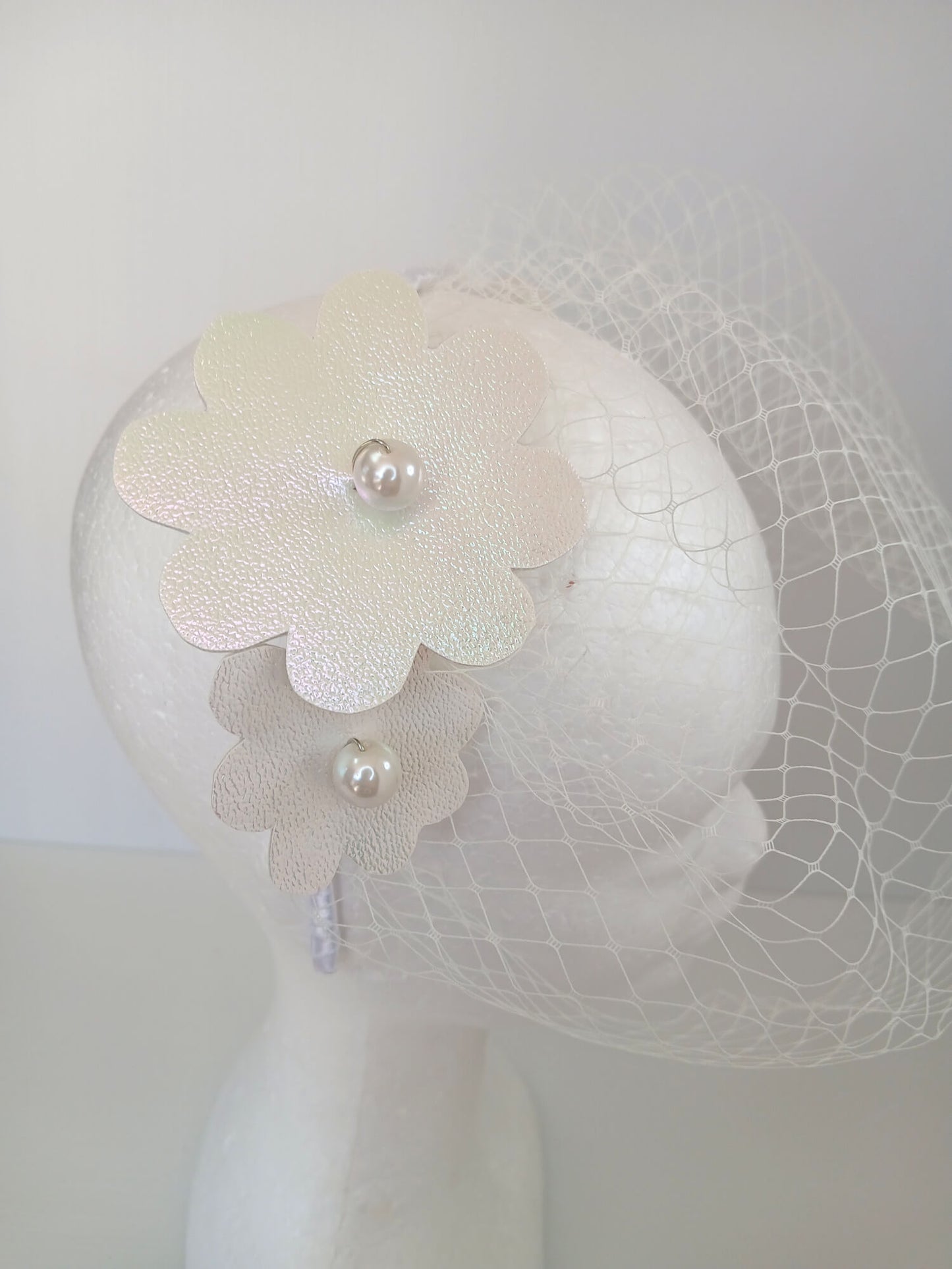 A picture of a White Pleather Veiled Millinery Headband by Melissa Rath Millinery.