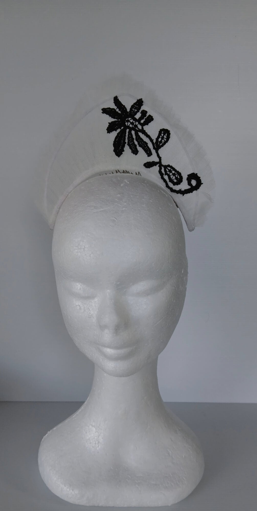 A picture of a white tulle crown by Melissa Rath Millinery.