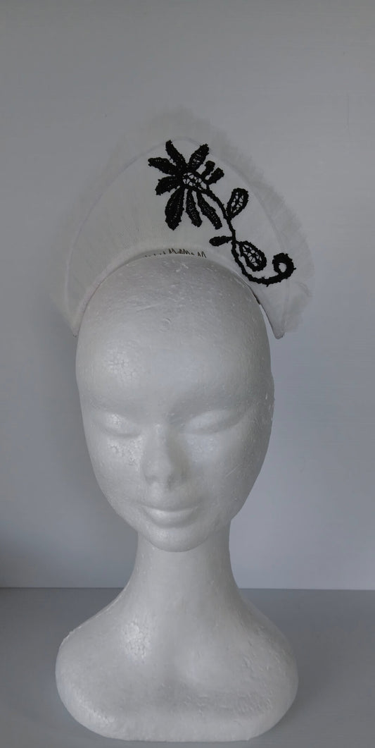 A picture of a white tulle crown by Melissa Rath Millinery.