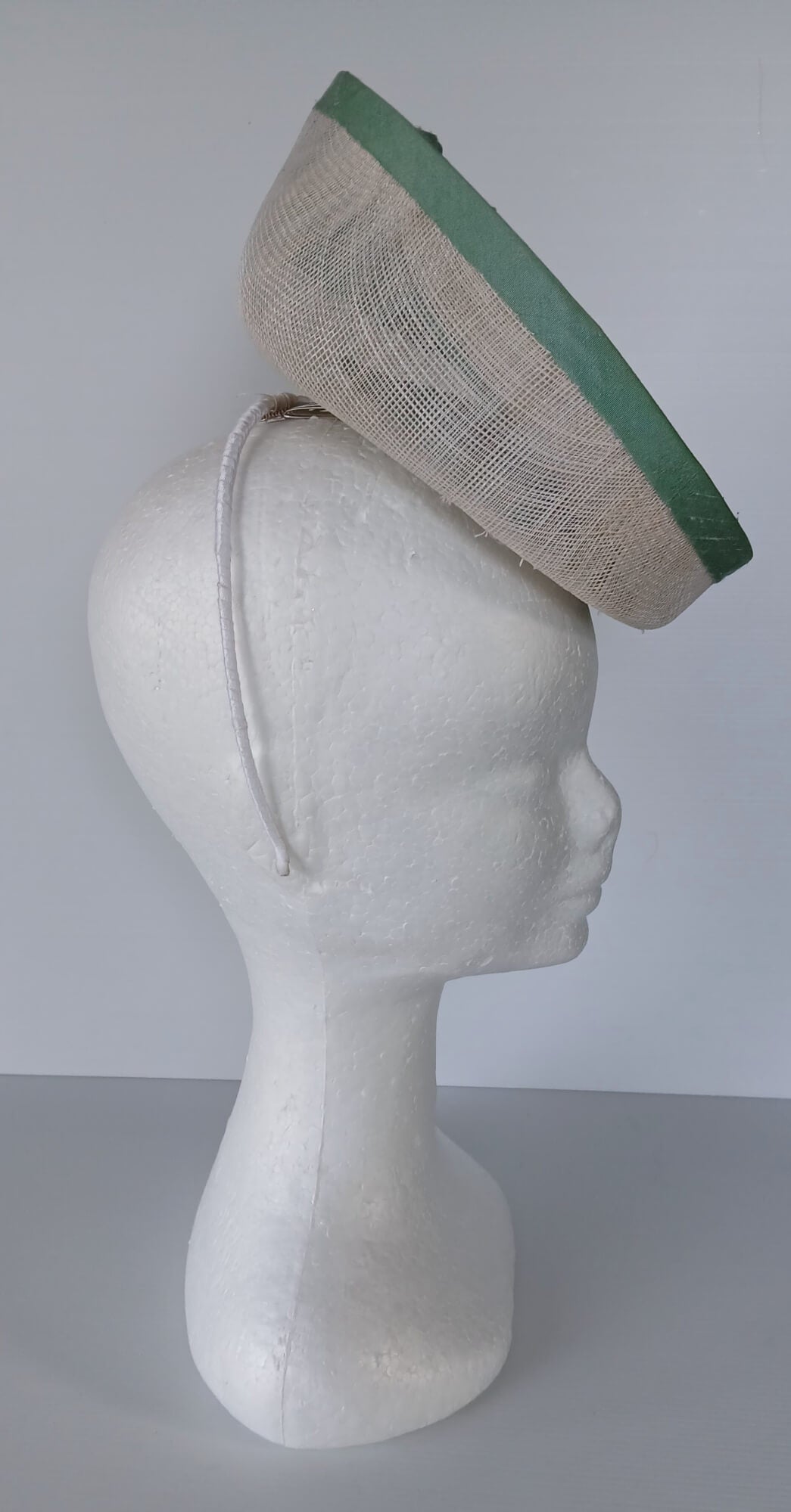 A picture of a White and Green Saucer Hat by Melissa Rath Millinery