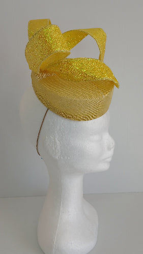 A picture of a yellow sinamay fascinator with a wired bow by Melissa Rath Millinery.