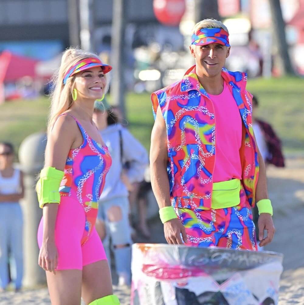 A picture of Margot Robbie as Barbie and Ryan Gosling as Ken in a fluro workout gear and coordinating sun visors