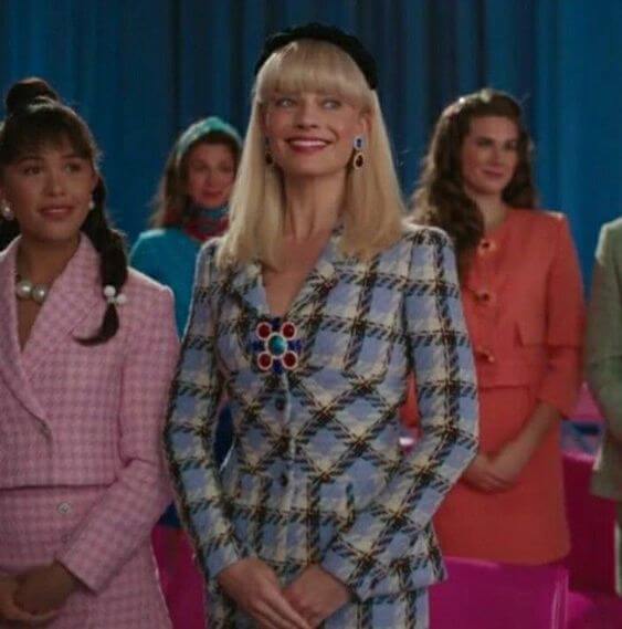 A picture of Margot Robbie as Barbie in a blue suit and coordinating headpiece
