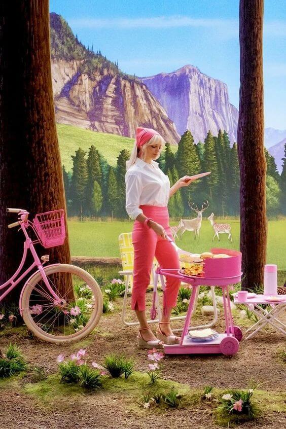 A picture of Margot Robbie as Barbie in a pair of pink cropped pants with a white blouse.