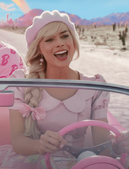 A picture of Margot Robbie as Barbie in a pink dress and pink matching beret