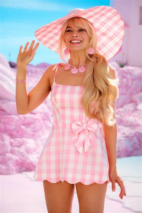 A picture of Margot Robbie as Barbie in a pink gingham dress and matching sun hat.