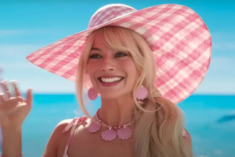 A picture of Margot Robbie as Barbie in a pink gingham sunhat