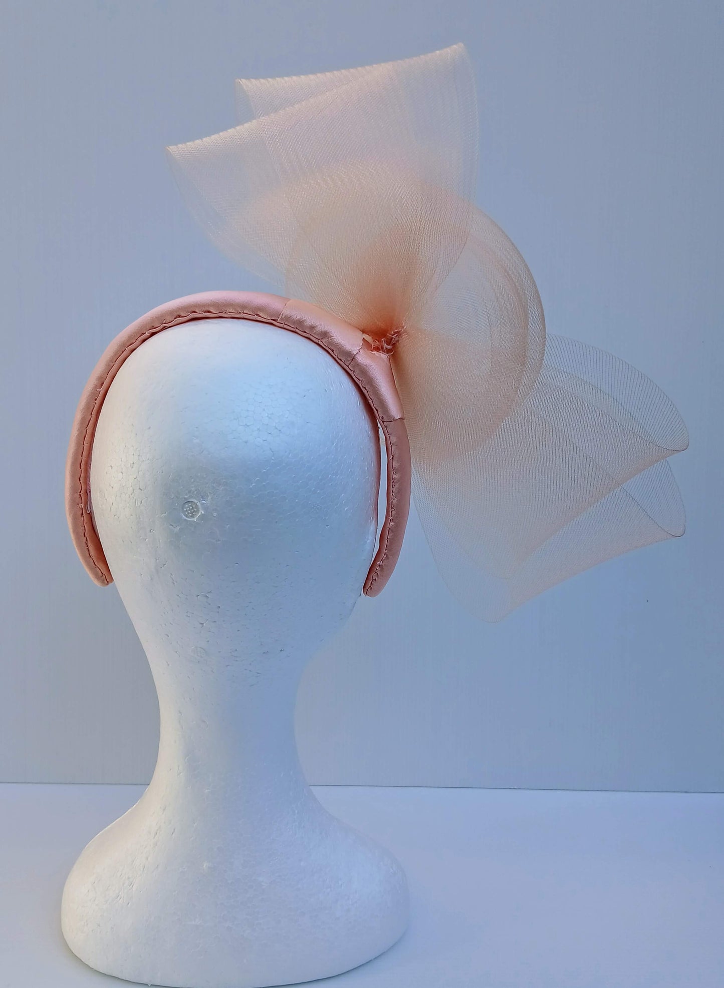 A picture  of an Apricot Crinoline Bow and Rose Headband by Melissa Rath Millinery