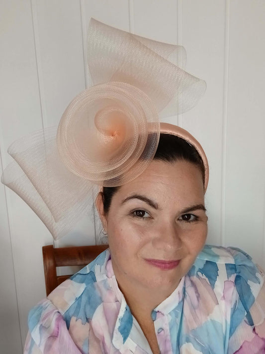 A picture  of an Apricot Crinoline Bow and Rose Headband by Melissa Rath Millinery.