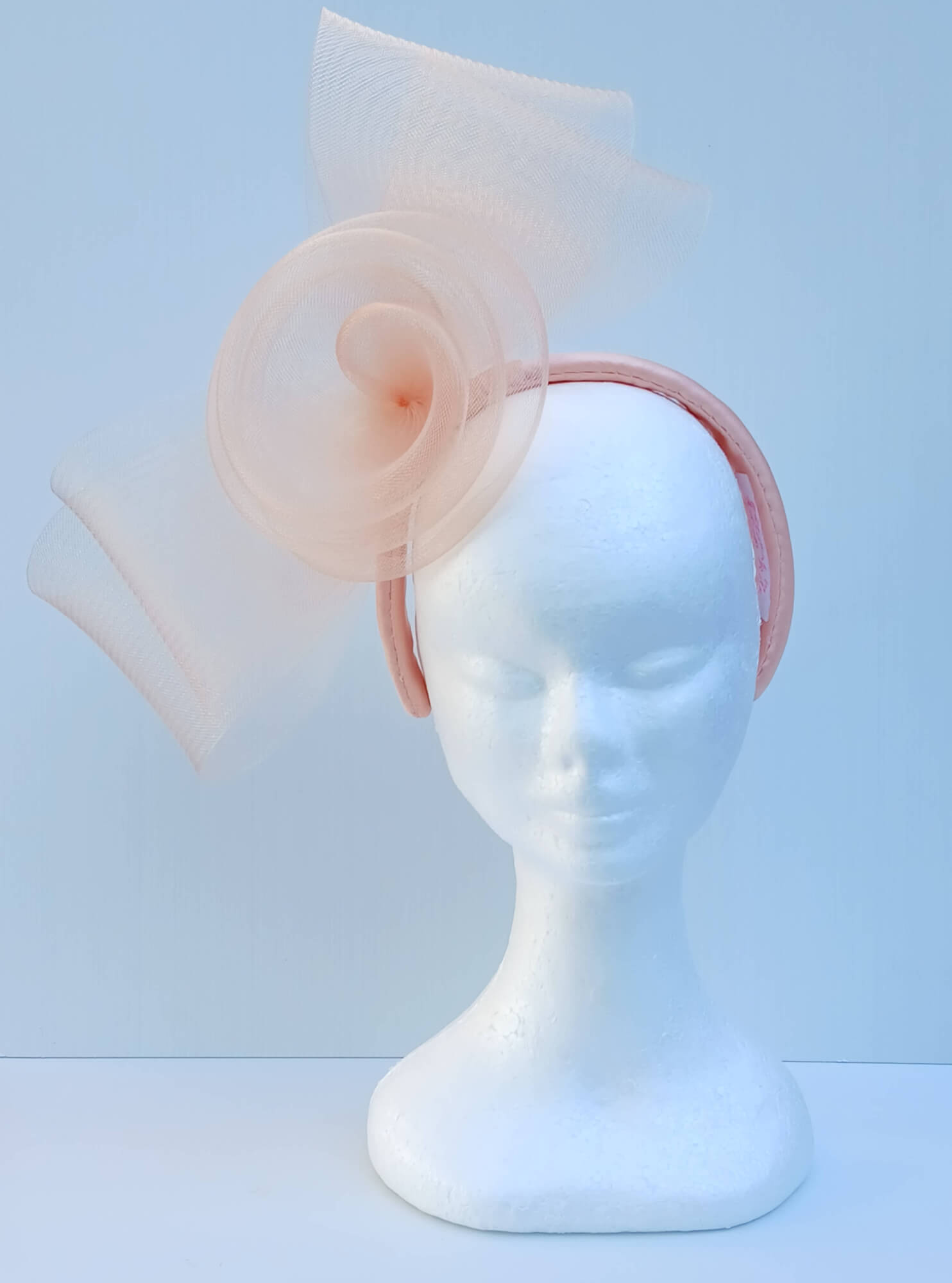 A picture  of an Apricot Crinoline Bow and Rose Headband by Melissa Rath Millinery.