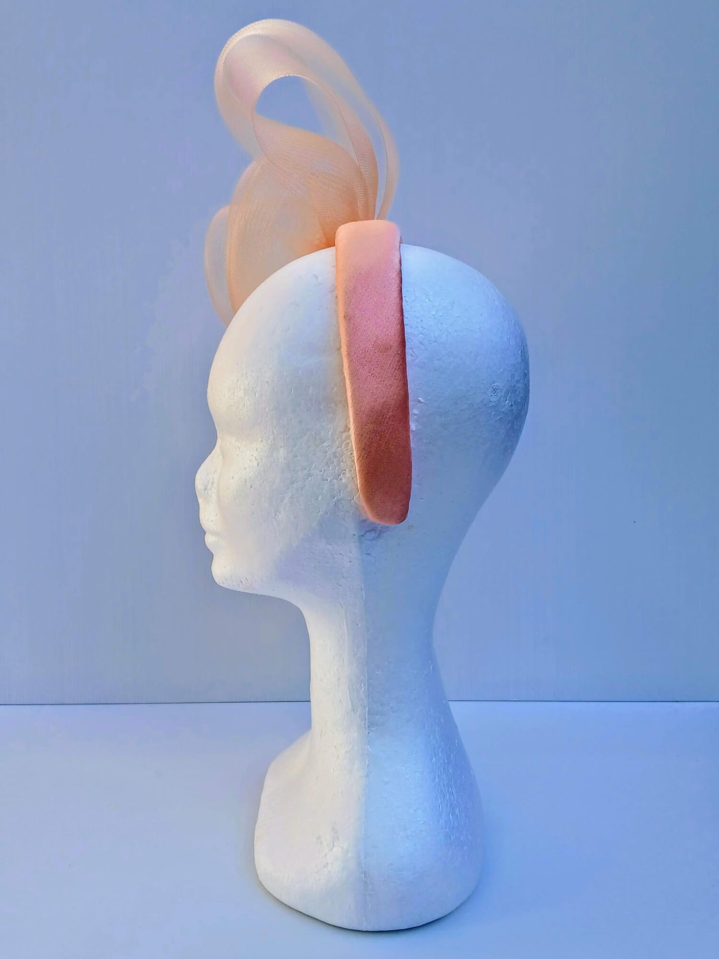 A picture  of an Apricot Crinoline Bow and Rose Headband by Melissa Rath Millinery.