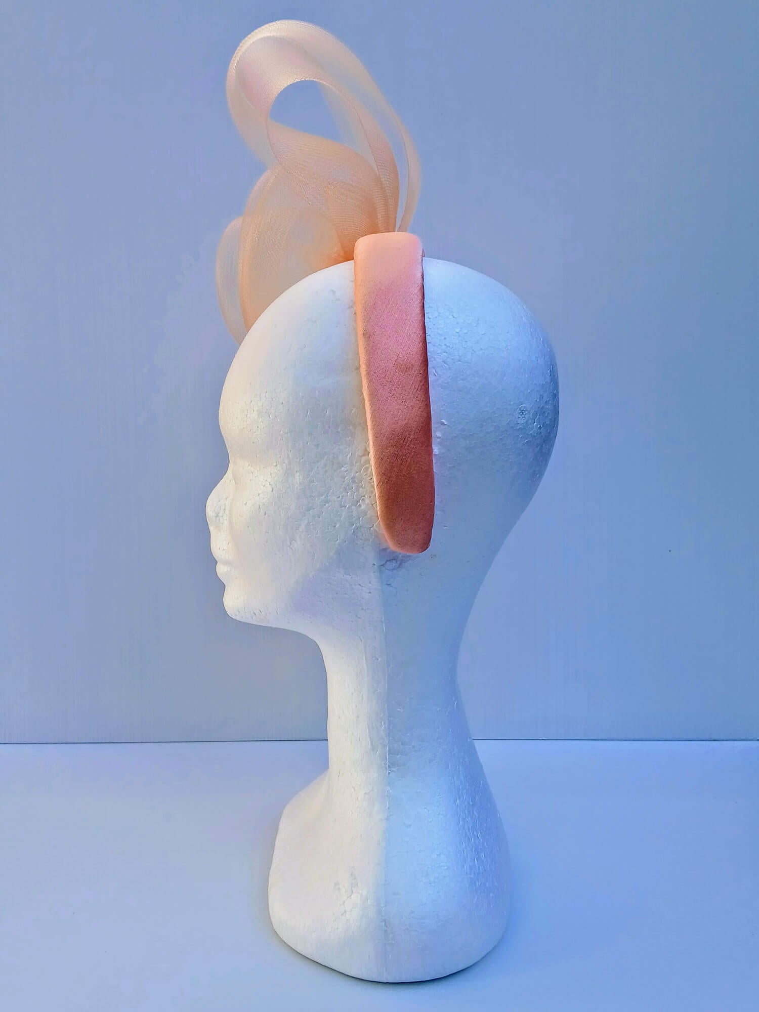 A picture  of an Apricot Crinoline Bow and Rose Headband by Melissa Rath Millinery.