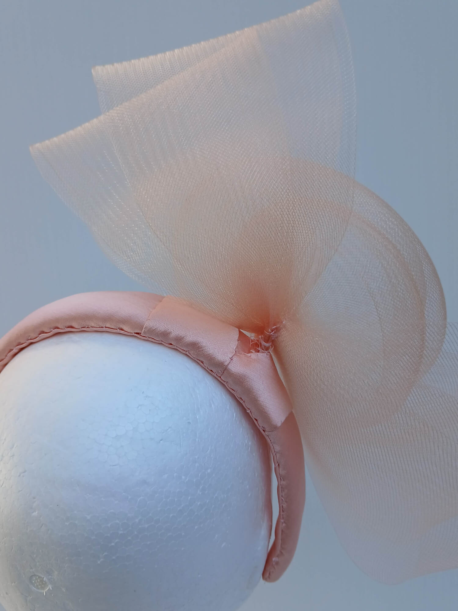 A picture  of an Apricot Crinoline Bow and Rose Headband by Melissa Rath Millinery.